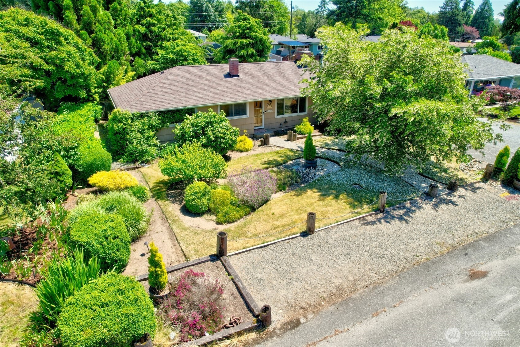 This beautifully maintained and cherished one-level home is a rare find, offering warmth, character, and thoughtful updates throughout. With 2 bedrooms, a den with loft, formal living room with stone fireplace and dining room, and a cozy family room featuring a wood-burning free-standing wood stove.  There's space for every occasion.  The kitchen impresses with abundant counter space and cabinetry, while hardwood floors add timeless elegance through the main living areas.. A sauna rounds out the interior's wonderful extras. Major updates bring peace of mind — furnace and heat pump (new in 2020), water heater, roof, deck, and deck roof have all been updated. The heat pump ensures year-round energy efficiency.  The garage, at 14 feet long, offers room for a small SUV, recreational toys, or whatever your imagination allows. Step outside to your own private oasis. The covered deck provides expanded enjoyment space, protected from the PNW weather. The backyard is a masterpiece of landscaping, complete with a pond and bridge, a generous storage shed, and lush greenery that makes every day feel like a retreat. This is the one you've been waiting for.