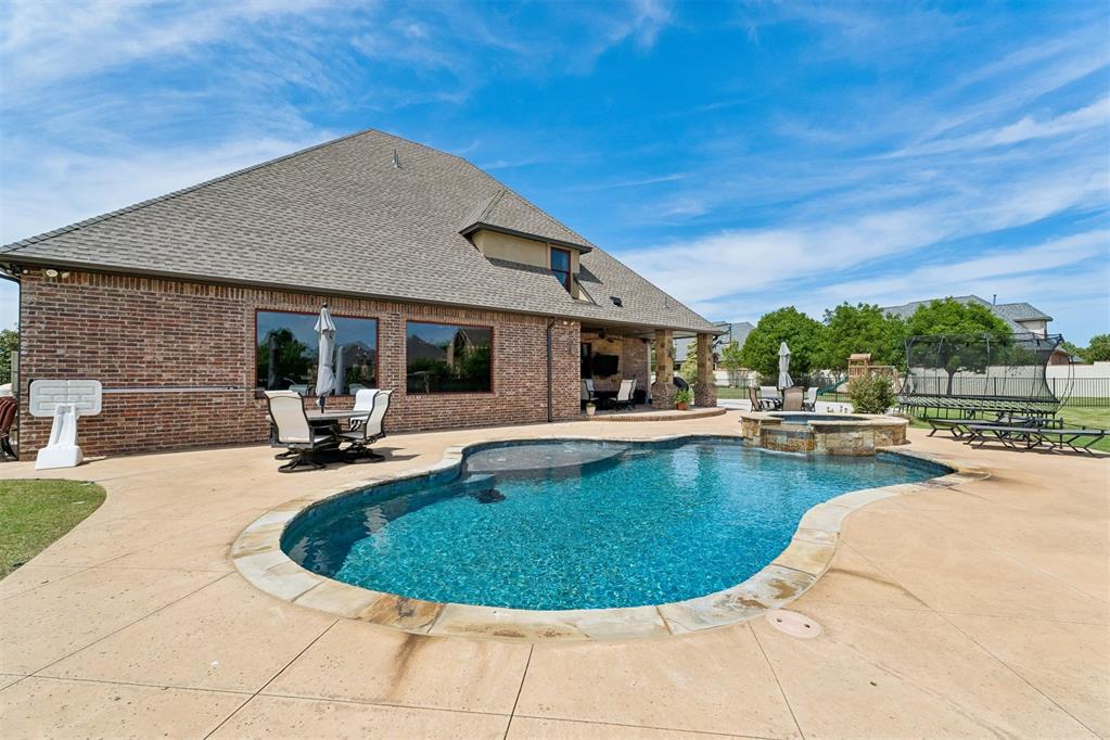 MUST SEE this Stunning Custom Built Home in Esperanza North-MOVE IN READY with Pool & Sports Court area! This beautiful home offers it ALL! This impressive home offers 4 large bedrooms, 4 full baths + 1/2 bath, 3 car garage, true office, oversized living areas & more. Inside this 1 owner home features 2 bedrooms downstairs including a huge primary suite, wonderful family living area with stone fireplace open to stunning kitchen & dining area. The classic kitchen features KitchenAid double ovens, gas cooktop, built in fridge/freezer, Scottsman ice maker, eat in bar area plus island, walk in pantry and TONS of storage! The primary suite offers double sinks + vanity area, walk in shower and separate soaker tub, primary closet of your dreams plus a laundry area connected to the closet. The other side of home features wonderful office space with built-in area & a guest bedroom with on-suite bath & large closet. Upstairs is a kids paradise featuring a wonderful game room with built in snack area area plus a bonus area for more play space, stackable washer & dryer, 2 large bedrooms with connecting bathrooms and plenty of closet space. This home offers a walk out attic for easy storage. Step into a backyard oasis with a saltwater sports pool plus hot tub, covered patio area, half moon basketball area with goal & plenty of yard for pets and kids to play. The 3 car garage is tandem with an XL in ground storm shelter. HOA covers weekly yard mowing, seasonly fertilizer & mulch treatments, flowerbed cleaning and the Neighborhood Pool is a huge bonus. Call Us today to see this ShowStopper home in Edmond