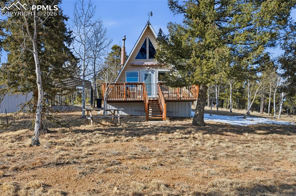 Fantastic Pikes Peak views set the stage for this beautifully remodeled A-frame mountain retreat! With southern exposure and surrounded by towering aspens on a private half-acre lot, this modern cabin offers the perfect blend of rustic charm and contemporary updates and makes a perfect Airbnb or vacation cabin rental Completely remodeled just six months ago, the home features new flooring, insulation, windows, roof, siding, doors, plumbing, skirting, kitchen cabinets, bathroom vanity, bathroom cabinetry, and pressure tank—giving you peace of mind and move-in-ready comfort. Inside, warm wood plank walls and built-in finish poles along the ceiling highlight the classic A-frame character, while the cozy wood-burning stove creates the perfect mountain ambiance and keeps the home warm all winter long. The charming, updated kitchen blends modern style with cabin appeal, and the main-level bedroom with attached bath offers convenient single-level living. A spiral staircase leads to the upper loft area with two beds and a delightful window seat—ideal for soaking in breathtaking Pikes Peak views by day and stargazing at night. Additional highlights include a tankless/on-demand water heater, high-efficiency systems, a carport, and a workshop for all your mountain projects and gear. Whether you’re looking for a peaceful full-time residence, weekend escape, or vacation rental opportunity, this property delivers. Located just 6 miles from downtown Woodland Park and 20 miles to Colorado Springs, you’ll enjoy the perfect balance of seclusion and accessibility in this stunning mountain getaway.