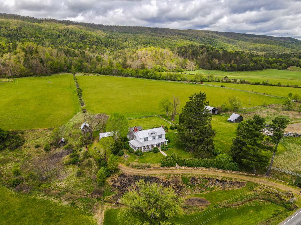 First time ever offered: Historic 472 Acre Willowbrook Farm in the mountains of Bastian, Virginia. A truly rare offering, this remarkable 472+ acre farm blends rich history with exceptional natural beauty. Featuring extensive Wolf Creek frontage, approximately 90 acres of cleared, usable, and relatively level fields, and a vast expanse of mature woodland, the property is ideal for farming, recreation, or creating a private legacy estate. The property is further improved by farm buildings, a silo, and additional outbuildings that support agricultural use and add to its charm and functionality. At the heart of the property stands a 2,200+ square foot home with origins dating to the late 1790s. The double chimney bears a brick carved “1804,” a testament to its historic roots. The original rooms on either side of the chimney are built from hand-hewn logs, later enclosed in brick, preserving the craftsmanship of the era. Inside, you'll find wide heart pine flooring, tongue-and-groove walls, multiple fireplaces, and a light-filled sun room that allows you to enjoy the surrounding landscape year-round. The original embossed tin roof remains, reflecting the home's enduring quality. A classic rocking chair front porch offers the perfect place to take in the sweeping mountain views that stretch in every direction and complete the picturesque setting. With its combination of history, productive land, abundant wildlife, and breathtaking scenery, it's truly a one of a kind offering. Properties of this size, history, and beauty are seldom available—a once in a generation chance to own a true Virginia landmark.