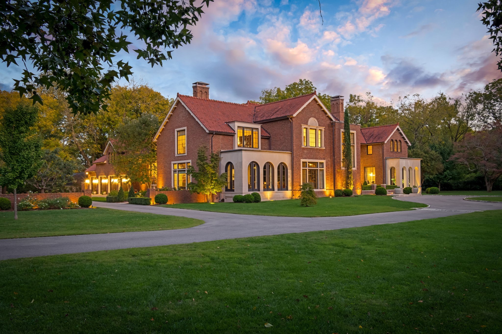 Located in the heart of Oak Hill, this extraordinary estate offers over 9,300 sq. ft. of refined living stretching over nearly 2.5 acres. Designed by architect Ron Farris & completed in 2016, with landscape architecture by Anne Daigh, the residence reflects timeless European inspiration with impeccable craftsmanship and attention to detail. Handmade Old Carolina brick in a Flemish bond pattern, a reclaimed 1890s Ludowici clay tile roof, solid limestone accents & vintage fixtures sourced from Paris and Italy create a rich architectural character rarely seen in Nashville. The interiors are equally impressive, blending grand scale with intimate detail. French-polished limestone and quarter-sawn oak floors flow throughout, complemented by soaring 10’6” ceilings. Custom stairwell balusters modeled after Paris’ Cimetiére du Père-Lachaise and oversized fireplaces elevate the home’s bespoke feel. The gourmet kitchen features marble countertops, dining and luxury appliances near expansive living and entertaining areas. A sumptuous primary wing offers a spa-inspired bath with dual vanities, steam shower & radiant heat flooring, along with dual walk-in closets and a dedicated exercise room, providing a private retreat within the home. In addition, a guest wing with a separate entrance ensures privacy and flexibility. Thoughtful modern amenities enhance everyday living, including geothermal energy with a future-ready pool loop, Sonos sound system, Lutron lighting & drapery controls, central vacuum, whole-home water filtration, instant hot & carbonated drinking water, and discreetly designed vents and finishes. Functional conveniences such as a 4-car pass-through garage with epoxy flooring, laundry chute, elevator shaft & abundant storage complement the home’s elegance. An extensive pool plan has been created & can convey.