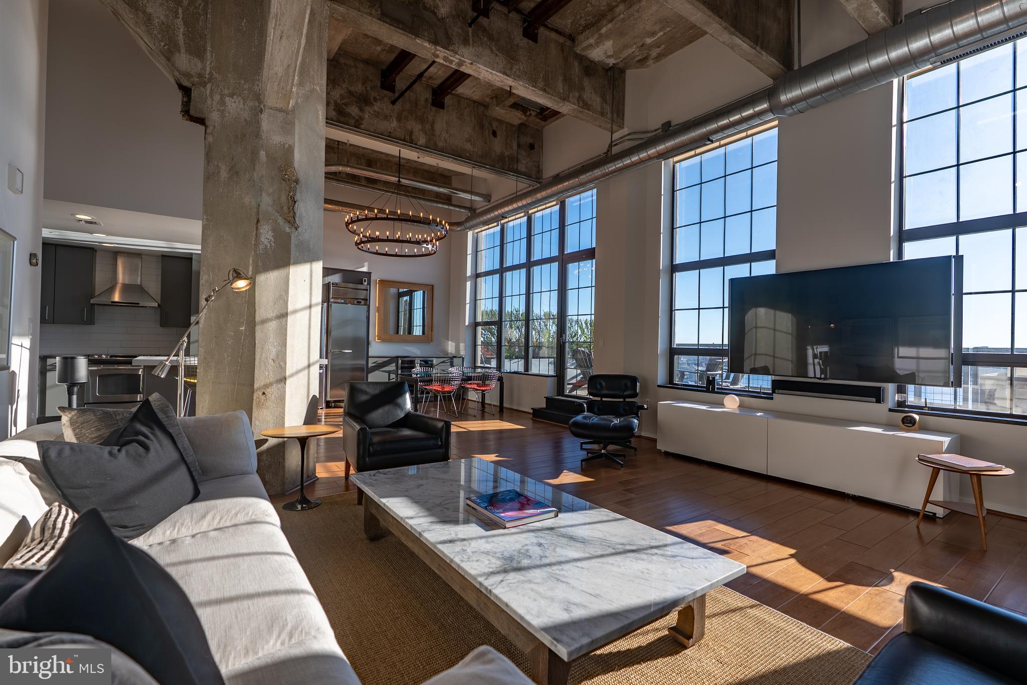 Welcome to unit 1413 at Silo Point — one of Baltimore's most iconic addresses. This expansive 2,388 sq ft residence offers a rare combination of scale, style, and sweeping waterfront views from the 14th floor of this celebrated converted grain elevator in the heart of Locust Point. The open-concept living and dining area features soaring 19-foot ceilings, rich hardwood floors, recessed lighting, and motorized window treatments that frame breathtaking panoramic views of the Patapsco River and harbor. The gourmet kitchen is equipped with quartz countertops, stainless steel appliances, a built-in bar, and a wine refrigerator — ideal for entertaining. The generous primary suite includes a large step-in closet and an updated private bath. Step outside to the sprawling  847 sq ft terrace balcony where harbor views stretch in every direction. The unit includes an in-unit laundry room and two deeded garage parking spaces. Building amenities include a 24-hour front desk, fitness center, game room, sky lounge, and elevators. Minutes from restaurants, shops, and waterfront attractions in Locust Point.