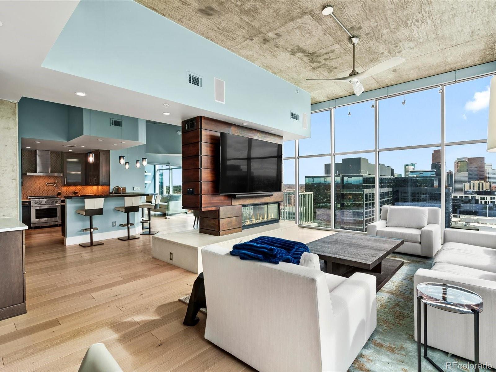 Penthouse 2315 is a rare opportunity to secure a premier skyline residence in Denver’s Riverfront Park.Positioned high above the city, this corner penthouse commands unobstructed panoramic views of the Rocky Mountains, Commons Park, and the downtown skyline, including Coors Field. Expansive floor-to-ceiling glass creates a dramatic backdrop of natural light by day and city illumination by night.Designed for elevated entertaining and refined daily living, the great room features a striking three-sided fireplace, built-in wet bar, and seamless integration to the dining space. The chef’s kitchen is appointed with premium appliances, custom cabinetry, and sleek modern finishes.The primary suite offers privacy and scale, complete with a spa-style bath featuring heated towel warmer, bidet, and a custom walk-in wardrobe. The secondary suite includes an en-suite bath and architectural glass detailing, ideal for executive office use or distinguished guest accommodations.Integrated whole-home automation, surround sound, and motorized window treatments enhance comfort and convenience.Included:Two premier side-by-side parking spaces in the heated garageDedicated EV charging stationPrivate garage-level storage suiteBuilt-in ice maker and installed media componentsGlass House residents enjoy a fitness center and outdoor pool, along with immediate access to Denver’s most desirable dining, cultural, and recreational amenities.This residence is well-suited for buyers seeking a lock-and-leave lifestyle, executive pied-à-terre, or a primary urban retreat with privacy and presence.