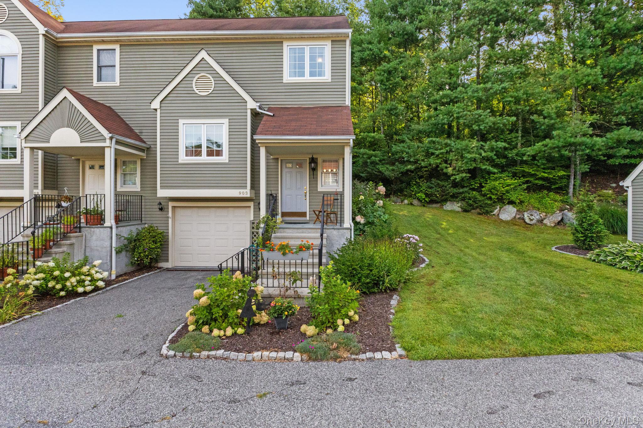 Move right into this beautifully maintained, sunny and bright 2 bedroom, 2.5 bath end unit in sought-after Guard Hill Manor. The home offers a neutral palette, inviting flow, and numerous updates including energy-efficient windows (2016), central air, newer appliances, gas fireplace (2018), water heater (2021), and freshly cleaned wall-to-wall carpeting (2025).

The living room with sliding doors opens to a private deck and flagstone patio bordered by mature perennial plantings. The eat-in kitchen features Swanstone countertops and resurfaced cabinets. Upstairs are two bedrooms with ensuite baths, laundry. Lower level provides spacious storage, utilities, and access to the garage with tiled floor (2017).

Guard Hill Manor residents enjoy outstanding amenities including a pool, tennis, playground, and basketball court. Convenient location just minutes to Metro North, shops, and restaurants. Taxes do not include STAR deduction.