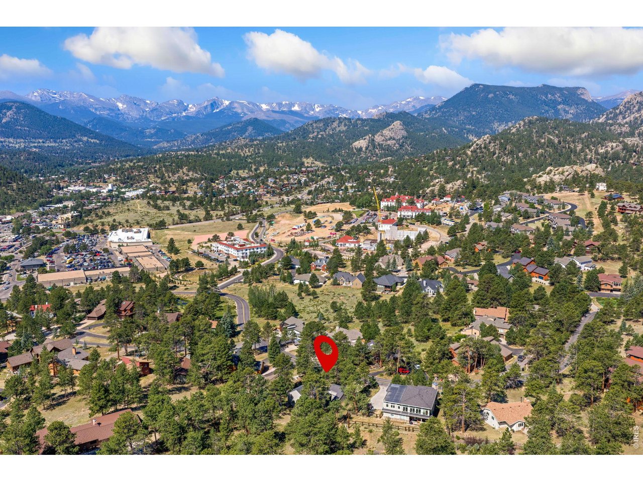 This charming single-family residence offers the perfect blend of comfort, style, and functionality. Nestled in the desirable neighborhood known as Stanley Hills, this home is ideal for anyone seeking privacy and a welcoming atmosphere. This 2-bedroom, 2-bath home is conveniently located near downtown Estes and all the summer activities it offers, and only a short walk from the Lake Estes walking trail. The kitchen is designed for both everyday living and entertaining, and open to the living room, which showcases a floor-to-ceiling mossrock, wood-burning fireplace, vaulted ceilings, and access to the heated sunroom where you will enjoy a beautiful view of Longs Peak. A guest room and 3/4 bath complete the main level. Upstairs is the primary bedroom, with access to the heated sunroom (28x8) and large 3/4 bath with a remodeled walk-in shower. The front entrance has a private patio, with a quiet sitting area to enjoy your flower garden, and has access to the detached 2-car garage and private workshop. Not to be missed, and one of the highlights of this property is the backyard exterior space. It is adjacent to open space, offering a beautiful atmosphere of peace and tranquility. Must see!