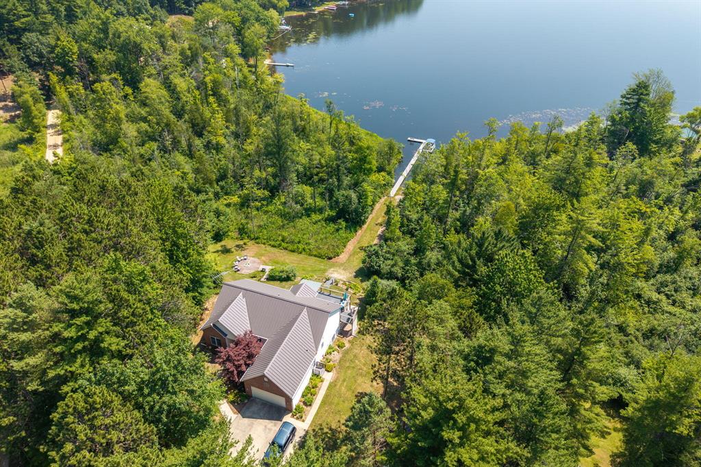 Nestled in an idyllic setting, this exquisite residence presents an unparalleled opportunity to experience the best of both worlds--the tranquil allure of a nature lover's paradise and the convenience of modern amenities just moments away. Boasting a rare and coveted waterfront location on 5 acres with over 430 feet of frontage on the enchanting all-sports Halls Lake, this property is a haven for those who appreciate the beauty of nature and the charm of lakeside living.With an ambiance that seamlessly combines the enchantment of a country retreat and the accessibility of urban conveniences, this exceptional home offers a serene escape while being a mere 3 miles from the nearest grocery store and just a 20-minute drive from the vibrant Mt. Pleasant community.The spectacular surroundings include a nature preserve across the lake, showcasing breathtaking views that serve as a constant reminder of the splendor of the great outdoors.
This impressive ranch-style residence features 4 bedrooms and 3 full bathrooms within its spacious layout. Upon entering, you are greeted by the inviting expanse with 10' ceilings, enhanced by an abundance of natural light and a seamless flow between the interior and the captivating outdoor scenery. The residence is thoughtfully designed with a mudroom, whole house vacuum, and generator for added convenience and functionality.
The master suite offers a private sanctuary, adorned with stunning views of the lake, an en-suite master bathroom, and a spacious walk-in closet. The well-appointed kitchen features cherry cabinets, hard surface counters, new flooring, and sliders leading to a low-maintenance composite deck with a power awning, creating an ideal setting for outdoor entertaining while reveling in the tranquil surroundings.
The lower level of the home serves as a versatile space, with a generously sized family room, an additional bedroom, a bathroom, and a convenient kitchenette, offering limitless possibilities for accommodating guests or creating a separate living area. A separate
