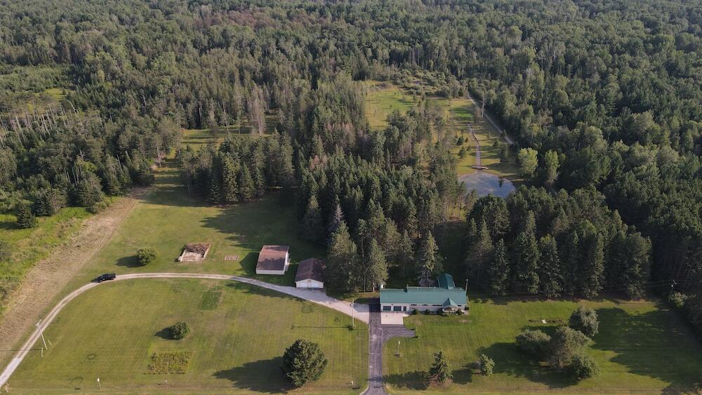 Welcome to 2220 M-30 in Alger, Michigan. This beautiful 3-bedroom, 2-bath custom home sits on approximately 20 meticulously manicured acres. The spacious open floor plan has a large kitchen with newer appliances and an island. The Sunroom provides gorgeous views of the pond and property in all directions. There is a 2.5-car attached garage. A whole-house backup generator system ensures that no matter what, you will never be without power. The Laundry room includes a newer washer and dryer and very nice cabinetry. The home has many other updates as well, like a new water heater, water softener system, bathroom flooring, and a metal roof. The home sits on a full unfinished basement that could easily be finished for additional living space.The back deck overlooks a 75'x150' pond that is 10' deep. The pond includes an awesome covered swing with a dock and a bridge as well.
In addition to the custom home there are 2 Pole barns for plenty of storage of all your toys, tools and equipment. The larger being 46'x36' with a lean-to. The 2nd pole barn is 30'x40' and has a very nice insulated and heated workshop that includes an air filtration system to keep the shop clean and dust free. There is also an 8x10 garden shed for additional storage of yard tools. A hunting blind overlooking the property behind the house is in place and ready for the fall!
The Property is loaded with wildlife including Deer, Turkey, Bear and many others. There are several fruit trees around the property which attract the deer to your back yard. A beautifully manicured lawn highlights the many mature trees around the house and pond.
This one is a must-see; it truly has it all.
