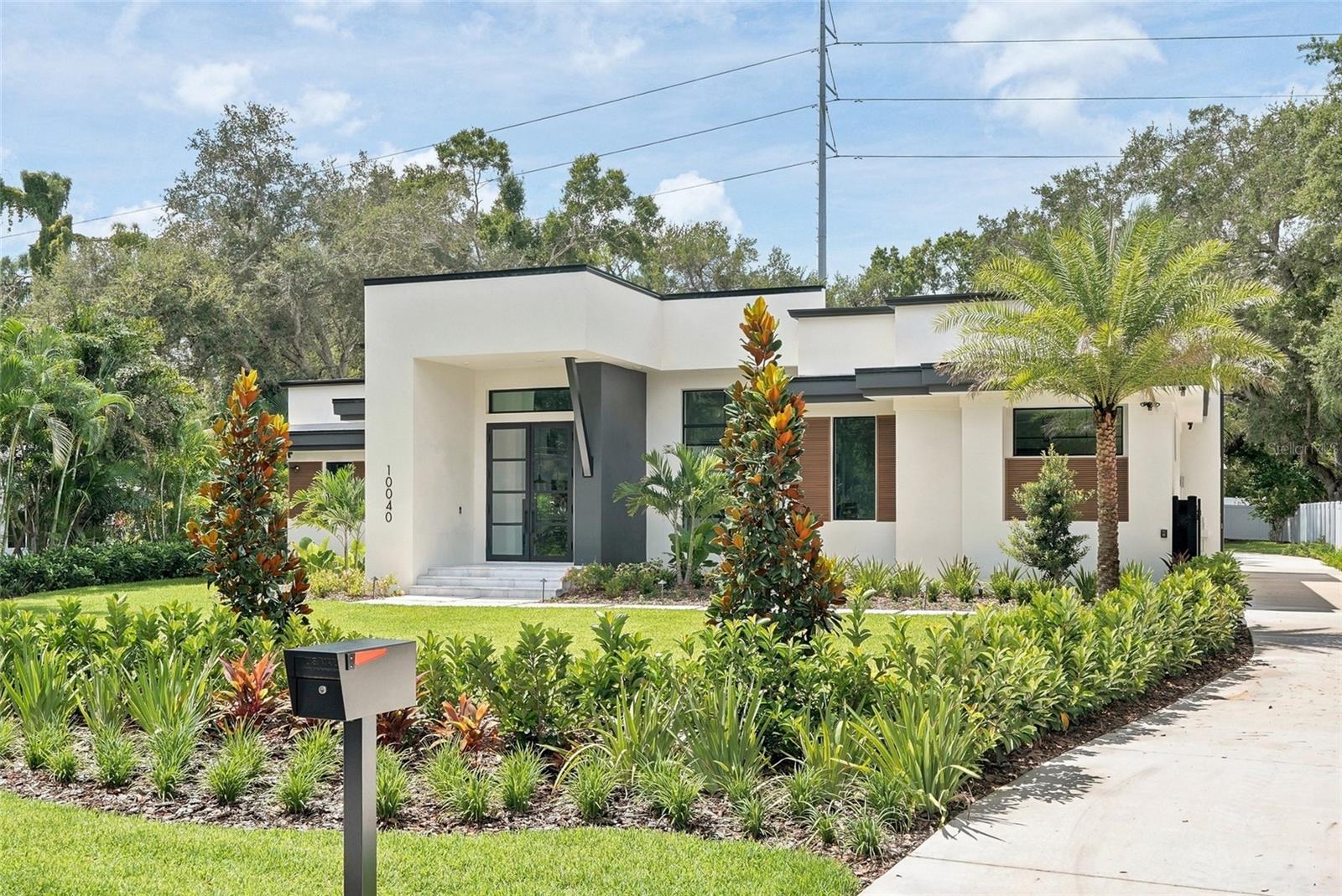 Welcome to 10040 59th Ave N ~ a stunning new construction home offering 3,983 sq. ft. of living space, 5 bedrooms, 5 full baths, and a powder room, thoughtfully designed for both everyday living and effortless entertaining. This home comes backed by a transferable 10-year structural warranty.Step inside to soaring ceilings in the main living area and a striking design palette of matte black interior doors against a soft neutral backdrop, a bold, modern contrast throughout. The kitchen is a true showstopper: custom maple cabinetry by Olde World Cabinetry in a charcoal stain finish, a dramatic full-height natural stone slab backsplash, a Monogram 42" built-in panel-ready refrigerator seamlessly integrated into the cabinetry, a Sharp microwave drawer, and a Café dishwasher — all finished with designer black and brushed brass hardware.The private primary suite features its own custom-built computer nook, ideal for a home office, along with a spa-inspired en-suite bath. Throughout the home you'll find designer Emser tile in every bathroom, each with a distinct pattern and finish, and waterproof, pet-proof Shaw luxury vinyl plank flooring for easy, worry-free living.Outside, the resort-style backyard is built for Florida living: a sparkling pool with sun shelf, two covered lanais, and a fully equipped outdoor kitchen featuring a Coyote 30" hybrid multi-fuel pizza oven, a built-in BBQ grill, a weatherproof outdoor refrigerator, and a beverage fridge.This home was built with peace of mind in mind: a Generac whole-home standby generator with WiFi remote monitoring, a Trane smart WiFi-enabled HVAC system, impact-rated windows and doors with a 10-year manufacturer warranty, a tankless Rinnai water heater, and a home already wired for whole-home audio, smart automation, and a MyQ smart garage door. The property also sits in Flood Zone X, meaning no flood insurance is required.Located 20 minutes from downtown St. Petersburg and 5 minutes from the Gulf beaches, this is a rare opportunity to own a fully custom, brand-new home with no detail overlooked.
