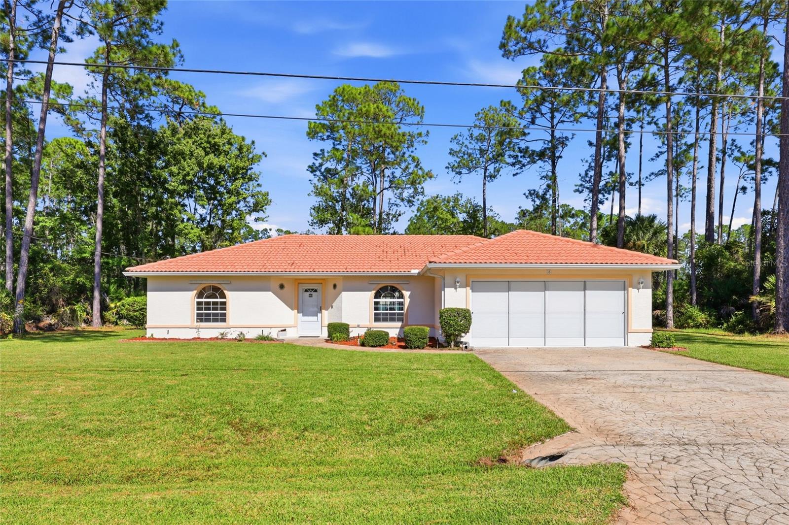 SPACIOUS HOMESITE, INVITING LIVING SPACES & SELLER ASSISTANCE WITH CLOSING COSTS! Discover the comfort and charm of this well-maintained 3-bedroom, 2-bath home situated on a generous 10,000-square-foot, fully fenced homesite. Nestled along a street of attractive, well-kept homes reflecting pride of ownership, this property enjoys the added benefit of vacant lots on both sides, providing an appealing sense of openness and privacy.Offering 1,412 square feet of thoughtfully designed living space, the home features an open, split-bedroom floor plan that balances comfortable everyday living with functionality. Volume ceilings, abundant natural light, and attractive wood-look flooring create a bright and welcoming atmosphere throughout the main living areas. The spacious living room flows effortlessly into the dining area and kitchen where generous counter space, and a convenient breakfast bar add character and practicality.Sliding glass doors extend the living space outdoors to an expansive 20' x 10' covered and screened porch, complete with ceiling fans and plenty of room for dining, entertaining, or simply enjoying Florida's beautiful weather. Beyond the porch, the oversized, fully fenced backyard offers endless possibilities for gardening, recreation, pets, or creating your own outdoor retreat. A detached storage shed provides additional space for tools and lawn equipment.The split-bedroom arrangement provides separation between the primary suite and secondary bedrooms. The primary suite features a private bath with dual vanities and a walk-in shower. A generously sized dedicated interior laundry room adds everyday convenience and valuable storage space.Additional features include a distinctive tile roof, gutters, a two-car garage, and an inviting exterior accented by arched windows and mature landscaping.AN ADDED INCENTIVE! The seller is willing to contribute toward the buyer's closing costs with an acceptable offer, providing an opportunity to reduce upfront expenses.With its spacious fenced homesite, comfortable interior, generous outdoor living space, and desirable neighborhood setting, this home offers an exceptional opportunity to enjoy the Palm Coast lifestyle. Come explore the possibilities and make it your own!