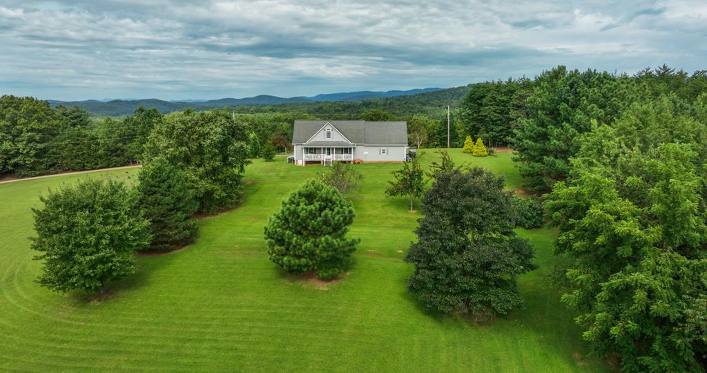 Are you looking for privacy and spectacular views all in one? This 9.4-acre property offers a mix of cleared land and woods, ideal for a hobby farm, hunting, or trails. Enjoy mature fruit trees—peach, plum, pear—along with grape vines, blueberries and blackberries, all producing. Tucked away on a dead-end road, the home features stunning views: Pilot Mountain, Sauratown, and Hanging Rock from the southern side, and the Blue Ridge ranges to the west. Inside, you'll find a spacious main-level suite is complemented by 2 bedrooms upstairs, 2.5 baths total, and a large bonus room above the garage. Walk-in pantry off the kitchen for plenty of storage. A charming nook, perfect for an office, frames the mountain vistas. With much of the groundwork already done, this property is ready for your vision. Road frontage on 2 roads gives plenty of access. Don't miss out on this rare opportunity to own both seclusion and breathtaking scenery.