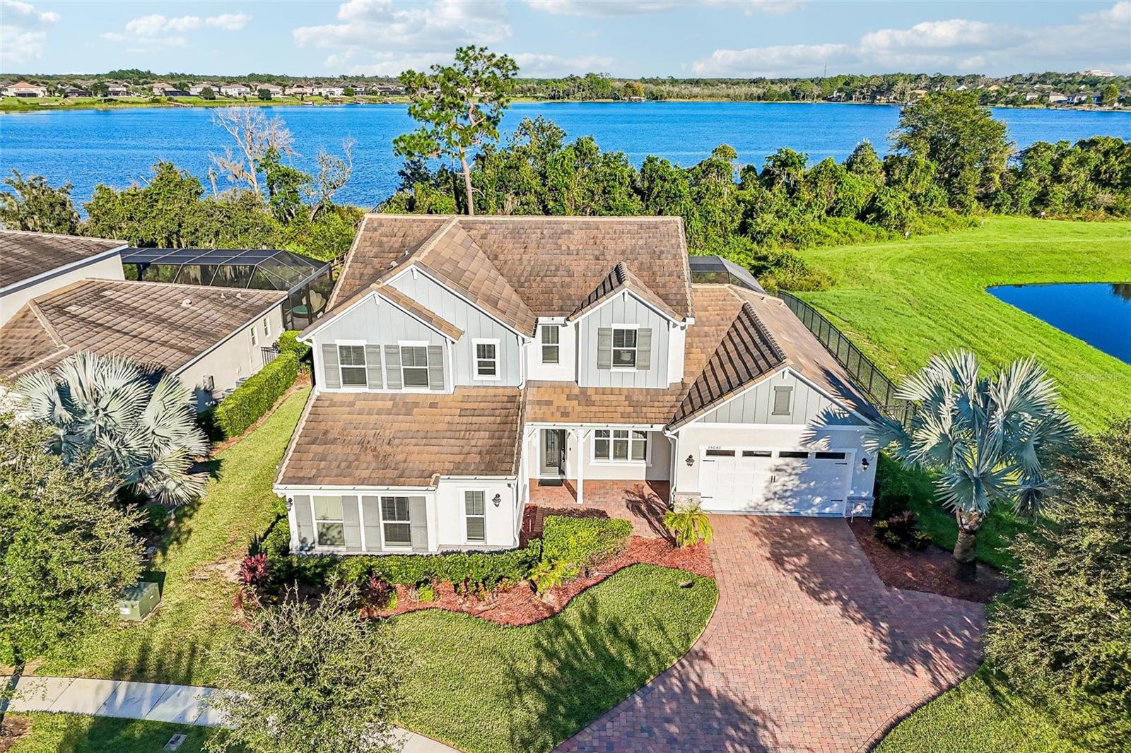LAKEFRONT LUXURY, a PRIVATE POOL, and room to grow in sought-after Winter Garden! BUILT IN 2021, this beautifully upgraded 5-bedroom, 3.5-bath home sits on an OVERSIZED .37 ACRE CUL-DE-SAC LOT overlooking LAKE HUCKLEBERRY in the Highlands at Summerlake Groves community. Surrounded by WOODED, LAKE, and POND VIEWS with minimal neighbors, this property offers a rare sense of privacy while keeping everyday conveniences close by. Lake Huckleberry is a 150-ACRE SKIABLE LAKE, and the county has approved a private dock to be built, opening the door to enjoying lake life right from your backyard! Beautiful landscaping, a PAVER DRIVEWAY, and inviting curb appeal welcome you home to a light-filled interior where thoughtful design meets comfortable luxury. Large-format MARBLE-LOOK TILE flows diagonally throughout the main living areas, complemented by crown molding, upgraded lighting, and elegant finishes. The OPEN CONCEPT living spaces are designed for effortless entertaining, with wide sliding glass doors connecting the indoors to the COVERED LANAI and SCREENED POOL. At the heart of the home, the UPGRADED GOURMET KITCHEN impresses with timeless cabinetry, glass-front display cabinets, crown molding, elegant countertops, a large ISLAND with seating, decorative tile backsplash, BUILT-IN GAS COOKTOP, stainless steel range hood, and statement pendant lighting. Your MAIN FLOOR PRIMARY SUITE offers a private retreat with a spacious en-suite bath featuring a double vanity and huge glass-enclosed, custom-tiled WALK-IN SHOWER with a built-in bench and rain shower head. Flexible living spaces include a formal dining area, FLEX/FAMILY ROOM, and an additional OFFICE or MAIN FLOOR BEDROOM converted from the original single-car side-load garage, ideal for working from home or creating a space that fits your needs. A PROFESSIONAL-GRADE ARAKNIS ROUTER AND WHOLE-HOME WI-FI SYSTEM keep you connected throughout the home. A custom BUILT-IN MUDROOM/DROP ZONE adds everyday convenience, while decorative iron staircase balusters, wood handrails, crystal-style chandeliers, and window blinds throughout bring character and style. Outside, your backyard feels like a private resort! Relax under the covered lanai, cool off in the sparkling pool with mosaic tile detailing, or entertain on the expansive paver deck, all within a screened enclosure featuring PANORAMIC SCREEN PANELS that showcase the lake and peaceful natural surroundings. A 6-FOOT BLACK ALUMINUM FENCE surrounds the side and rear yards, defining the outdoor space while preserving the open views. Located in the Highlands at Summerlake Groves, this home offers easy access to SR 429, shopping, dining, and all that Winter Garden has to offer, with sought-after A-RATED SCHOOLS – Summerlake Elementary, Hamlin Middle, and Horizon High. BONUS ~ FURNISHINGS ARE NEGOTIABLE! Spacious, beautifully appointed, and perfectly positioned for lakefront living, this is a home that truly offers something special!