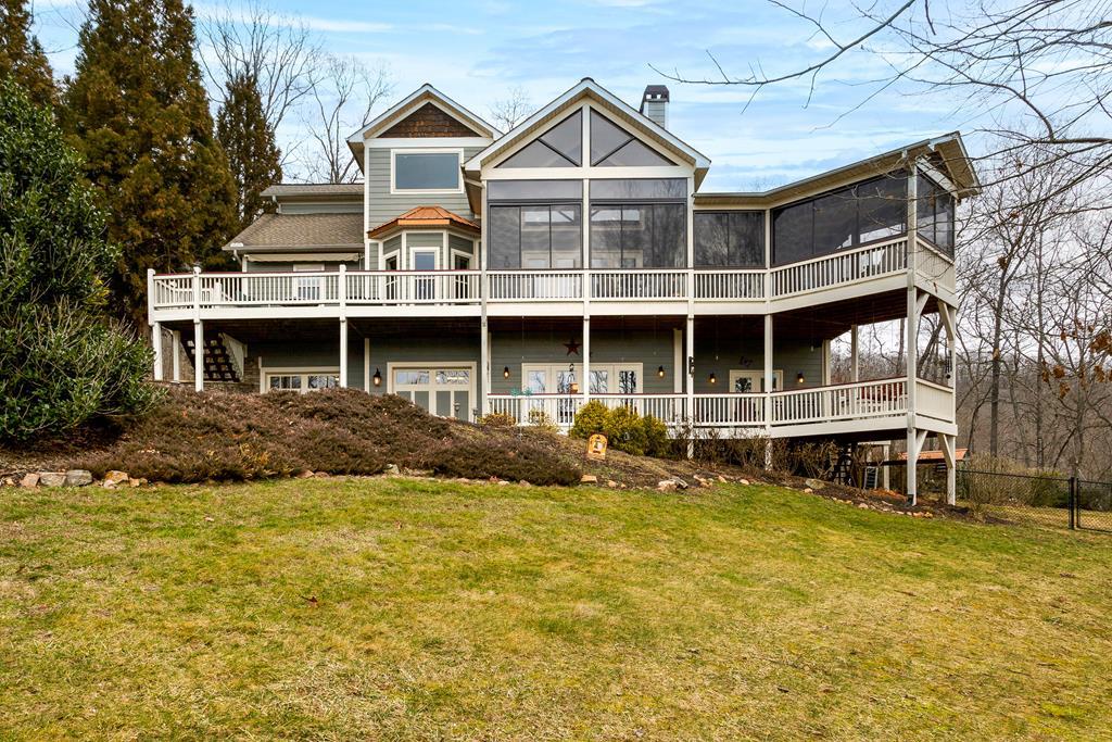 Welcome to your dream home with breathtaking views of the Lake, Mountain, and Brasstown Bald, nestled in the picturesque town of Hiawassee. This custom-built masterpiece features 3 bedrooms, 2.5 bathrooms, and an oversized 2-car garage, all conveniently close to town and surrounded by exquisite landscaping with seasonal lake glimpses. The main level invites you in with a seamless flow from the welcoming foyer to the grand great room, featuring a dramatic floor-to-cathedral ceiling stacked stone gas log fireplace. Relish the harmonious blend of drywall and wood as you enjoy meals in either the breakfast nook or the well-equipped kitchen, adjacent to the formal dining room. The spacious Master Suite stands out with its direct access to a screened/vinyl enclosed porch. Enjoy the spacious master bath boasting a luxurious tile shower and garden tub. Additional amenities include a deck, an expansive laundry room, a half bath, and a sophisticated pantry equipped with a dumbwaiter connecting to the garage. Explore the loft and you'll find an inspiring study area with a built-in desk for two, offering stunning views and substantial storage thanks to a large closet. The terrace level, accessible via a private entrance, hosts two bedrooms, a bathroom, a kitchenette, and a cozy family room with a stacked stone gas log fireplace, plus a porch for relaxation. This property offers abundant parking options with two driveways and includes a concrete pad designed for a 40' RV, complete with a 50 amp hookup. Delight in the granite finishes throughout the home and numerous upgraded features such as a security system, a sound system, and a whole-home Generac generator. This exceptional property deserves a place at the top of your must-see list!