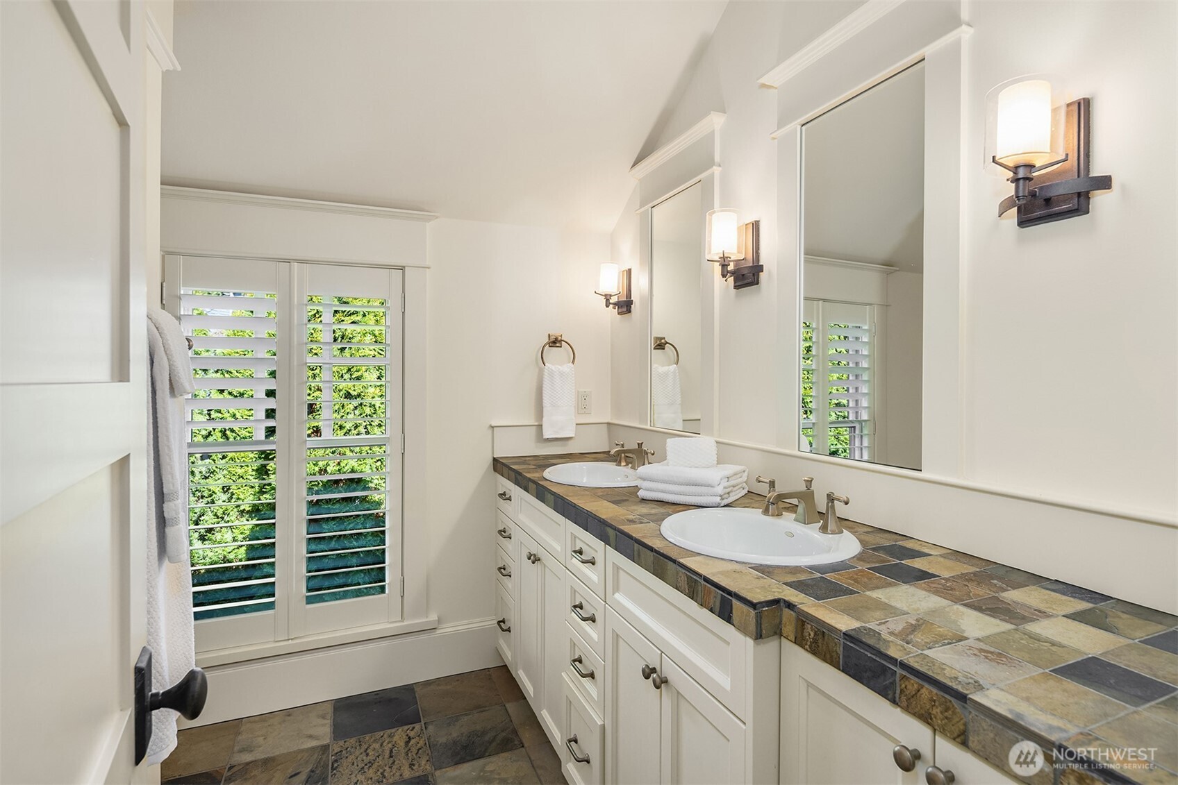 This lovely 3/4 bathroom features rich slate tilework creating a refined, textural and timeless finish.