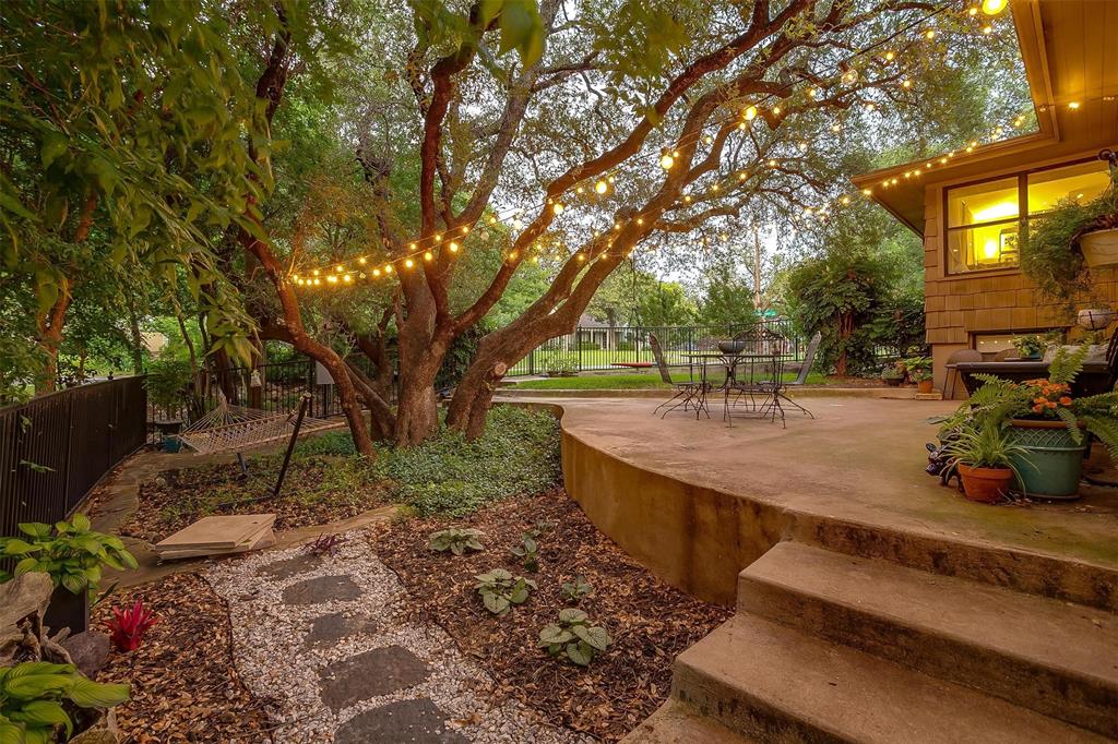Treehouse vibe! This stunning, remodeled modern home with a treehouse vibe is ready for its new owner. It’s perfect for entertaining, relaxing, and living! Step into the living room featuring an open-concept kitchen with an island that overlooks the dining areas, a second-level patio, and a lush canopy of trees. There’s even an outdoor kitchen with a bathroom, so no one needs to head inside. Enjoy evenings filled with entertaining, cooking, or simply unwinding. Storage is everywhere, from bench seats in the dining nook to large outdoor storage buildings. Even doing laundry is a joy in the spacious custom laundry room! Yard work is a breeze with a fully automated sprinkler system and well-established perennial landscaping. Winner for Yard of the Month 2023.  Additional updates include a new HVAC in 2024 with mini splits added to window-filled rooms for desired separate regulation, new high-end carpet and baseboards in 2024, a new roof in 2022, and a gorgeous gas direct-vent fireplace added in 2019.