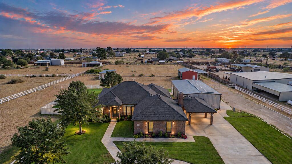 Located on a quiet neighborhood street, this beautiful Greenwood property sits on 3 acres offering multiple pastures, 2 barns, 5 horse stalls, and a huge 30x60 insulated shop with three 12' garage doors and office space. The home features an open layout, two living areas, built-ins, granite countertops, stainless appliances,   high ceilings, a formal dining area, updated sequestered primary suite, large closets throughout and a fireplace in the den. Water is not an issue here! Enjoy evenings on the covered porch surrounded by beautiful landscaping.