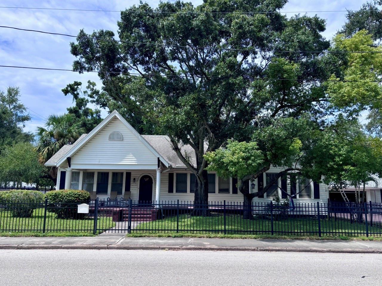 Investment Potential in Palmetto Beach neighborhood, one of Tampa’s historic coastal communities experiencing ongoing revitalization. Perfectly located just 1.5 miles from Historic Ybor City and a mere 2.5 miles from Downtown Tampa. Set elegantly on an oversized 77 by 118 foot corner lot directly across from the sparkling waters of McKay Bay, this 1933 bungalow represents a rare, defining opportunity in the Tampa Bay market. 2,168 square feet of living space with 3 bedrooms and 2 bathrooms is a dramatic architectural canvas waiting for its next chapter, whether that means a grand restoration or the creation of a brand new custom luxury estate.The home features 12-foot ceilings throughout, and sunlight pours through several large windows in each room. True craftsmanship echoes through the custom crown moldings, intricate ceiling dials, beautifully framed doors and windows, and graceful arched openings that connect the main living areas. A classic wood burning fireplace stands ready to serve as the heart of the home. Functional extras include a partially floored attic for abundant storage and a brand new roof installed in October 2024.An oversized detached two car garage provides exceptional utility, complete with a laundry room, storage room, and plumbing already in place for a half bathroom. The detached layout and generous lot size could offer potential for the future construction of a secondary living structure on site. The natural beauty of the McKay Bay bird estuary and the sprawling amenities of Desoto Park are right across from this property. Residents will enjoy immediate access to a waterfront playground, basketball courts, a soccer field, a skate park, walking and jogging trails, and a beautiful zero entry public pool.Location is everything, and this property sits at the epicenter of Tampa's most exciting multi-million dollar transformations. Just a little over a mile away, the 50 acre Gas Worx mixed use development will seamlessly connect Ybor to Downtown, while the Ybor Harbor project will introduce a vibrant waterfront boardwalk, premier dining, and lush green spaces. Even closer, the neighborhood is poised for an evolution. The City of Tampa’s Pathways to Palmetto Project is proposed to reconstruct the McKay Bay seawall, add modern sidewalks, and revitalize Bermuda Boulevard. The northern lot next door will have a new build, similar to the 2023 new build next to it, in 2026/2027. Please note, this property has experienced previous flooding and fire damage. It is being sold strictly as-is, presented as a full remodel opportunity or a premier tear-down site for an exquisite new construction build. Whether you are a local custom builder looking for your next marquee project, a seasoned investor ready for a major flip, or an ambitious primary buyer wanting to build a forever home with views of the water, bring your contractor and your imagination to claim your piece of the Tampa waterfront lifestyle.