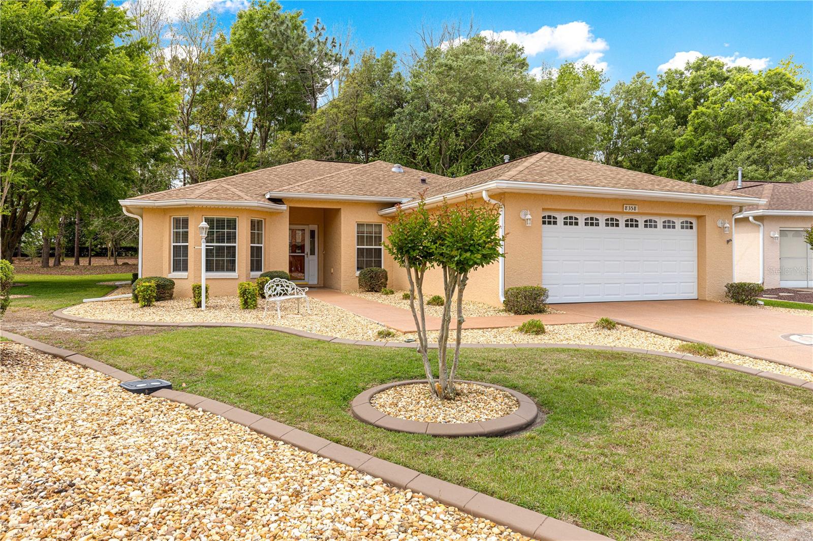 This Verbena model home in Indigo East, part of the On Top of the World 55+ community, showcases exceptional pride in ownership through its evident curb appeal and well-maintained features on a quiet street. The three-bedroom, two-bath split floor plan welcomes you into a spacious living room with an open view of the wooded nature area leading to a private lanai and backyard. Recent updates enhance its move-in readiness, including a new garage door opener with keypad, springs, and rollers (2019), A/C (2019), water heater and softener (2019), and roof replacement (2021).Key Upgrades and house improvements include a new kitchen sink, backsplash, and fresh interior paint, paired with stainless steel appliances that convey with the sale. The primary bedroom feels expansive with a tray ceiling, abundant natural light, and two walk-in closets. An eat-in breakfast area complements the kitchen setup.On Top of the World in Ocala, Florida, is a gated 55+ haven ideal for active adults, updated homes like this Verbena model command strong interest.