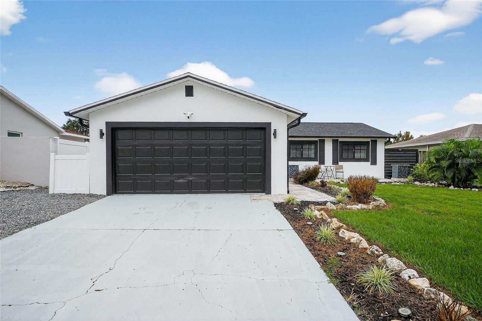 Set in a non-flood zone just minutes from Indian Rocks Beach, this beautifully renovated 3 bedroom, 2 bathroom, 2-car garage home delivers modern style and peace-of-mind updates from front door to backyard. An open floor plan connects living, dining, and kitchen spaces and brings in great natural light. Tile floors run throughout for a clean, low-maintenance finish, and recessed LED lighting brightens the living room and kitchen. The kitchen is the full package featuring new cabinetry, premium countertops, a stylish backsplash, stainless steel appliances, 2 barstool overhangs, and even pot filler! The primary suite offers a refined bathroom featuring a glass-enclosed walk-in shower with a built-in niche and shower bench, plus a dual-sink vanity. The second bathroom is also newly finished with quality tile work, a sleek vanity, and luxurious finishes. Out back, a fenced yard provides plenty of space for pets and play, along with a paver patio, a built-in outdoor fireplace, and a hot tub for relaxed evenings or weekend get-togethers. Big updates in 2024 include: Roof, Electrical panel, HVAC ducts, Water heater, and more! This quiet neighborhood offers quick access to beaches, parks, golf, dining, and everyday errands while maintaining a relaxed residential feel. Tour today to experience a move-in-ready coastal home with quality finishes and thoughtful updates.