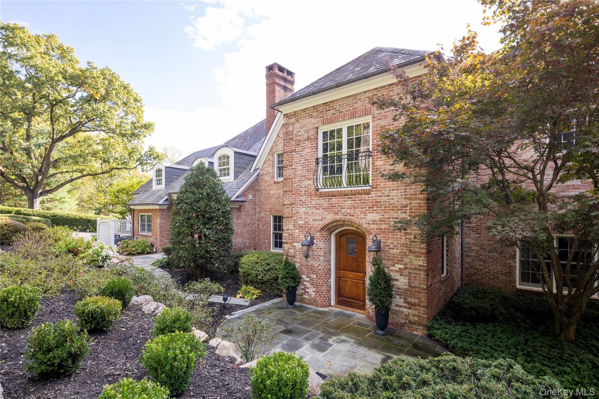 Discreetly set back from idyllic Feeks Lane in the historic hamlet of Mill Neck, this recently renovated Normandy country house anchors a private estate complete with 2 bedroom guest cottage, gunite infinity pool with spa, decorative pond and mature specimen trees set on 5.8 park-like acres.

Meticulously renovated for today’s lifestyle, the home features graciously scaled rooms, refined millwork, and elegant entertaining spaces.  A newly renovated chef’s kitchen featuring top-of-the-line finishes and appliances looks out over a bluestone and brick patio with a built-in grill.  A well-appointed mudroom with laundry and dog-washing station adds convenience. The formal dining room and large, elegant living room with wet bar provide a sophisticated setting for gatherings, while a bright sunroom and richly lacquered library add warmth and character.

Upstairs, the luxurious primary suite includes a spa-like ensuite bath and two spacious walk-in closets. Four additional bedrooms and three full bathrooms, along with a comfortable family room/den, complete the second floor.  The separate guest cottage has two additional bedrooms along with a full kitchen, spacious living room, 2 full bathrooms and built-in sauna.

Modern upgrades include gas fireplaces throughout, a professional-grade Aruba WiFi network with wired backhaul, multi-zone hard-wired Sonos sound system, whole-house Lutron lighting controls.  The property borders the Beaver Dam Nature Sanctuary and Preserve, offering unmatched tranquility and natural beauty.