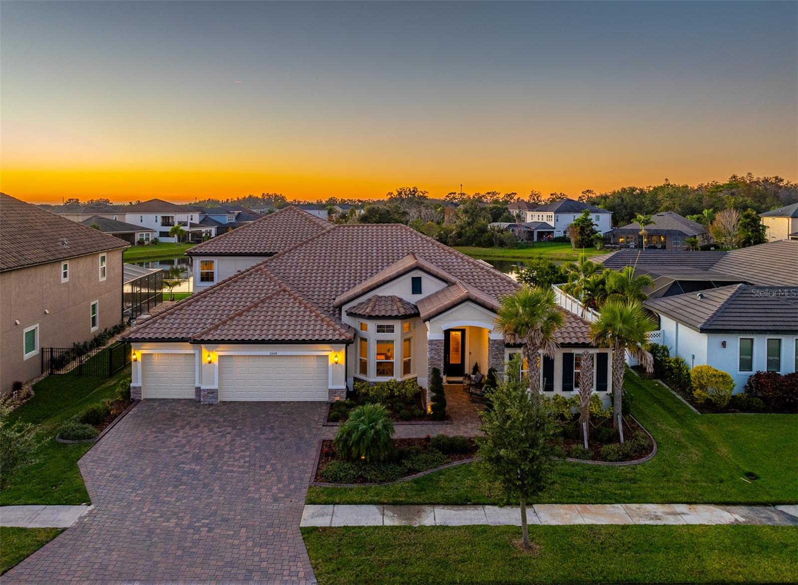 Welcome to this stunning MI-built home offering 5 bedrooms, 4.5 bathrooms, high ceilings—including elegant tray ceilings—and an incredible blend of comfort and luxury. With all bedrooms located on the first floor except for one, this thoughtfully designed floorplan provides ideal functionality for both everyday living and entertaining.Upstairs, you’ll find a spacious bonus room complete with a built-in bar, projector, and an additional bedroom and bathroom—perfect for guests, movie nights, or a private retreat.The home features wood laminate flooring throughout and “wood” tile in all bathrooms, adding both style and durability. The primary suite includes a large walk-in shower and a huge soaking tub, creating a spa-like experience right at home.The main living area impresses with a stone accent wall and cozy fireplace, while the gourmet kitchen boasts a gas range, stainless steel appliances, quartz countertops, tankless water heater, custom light fixtures, and automatic/electric blinds on the sliders. Enjoy outdoor living at its finest with a brand-new pool and spa, complete with water and fire features, all fully controlled by a convenient phone app. There’s also a gas hookup on the patio, perfect for grilling or an outdoor kitchen. The home faces west, offering breathtaking sunsets over the pond.Located in the highly desirable WaterGrass community, residents enjoy resort-style amenities, including multiple pools (lap pool + splash pad), a large covered lanai, clubhouse with office/meeting spaces, tennis and basketball courts, playgrounds, and a fitness center—all for an incredibly low HOA of just $161/year.Conveniently situated just across the street from the famous Epperson Crystal Lagoon, and close to Publix at Innovation Springs, shopping, dining, and the outdoor KRATE mall. Commuting is easy with Downtown Tampa only 35 minutes away, Tampa International Airport about 45 minutes, and Orlando & Disney less than 1.5 hours.This exceptional home offers the perfect balance of luxury, location, and lifestyle—don’t miss the opportunity to make it yours!