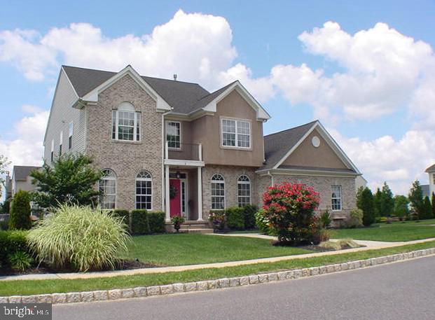 Wake up in Meadow View, where tree lined streets, cobblestone curbs, and quiet cul de sacs make every day feel a little more relaxed, yet you’re just minutes from Cinnaminson’s parks, shops, dining, and an easy commute into the city.  This corner lot brick front colonial at 8 Saratoga Springs Dr is the kind of home that welcomes you back with colorful landscaping, a side entry garage, and a charming front porch that hints at the warm spaces inside.Step into the dramatic two story foyer and you’re greeted by sunlight, an elegant chandelier you can lower for easy cleaning, and an open balcony above that makes the whole house feel connected. The front office is perfect for working from home with a view, or it can be styled as a cozy library, playroom, or music room. The dining room, with its big windows and arched transoms, sets the scene for holiday dinners, birthday parties, and all the “everyone comes here” moments.The oversized kitchen is where life really happens—morning coffee at the island, homework at the big table that easily seats eight, and weekend cookie marathons thanks to all that counter space and 42" cabinetry. A pass through over the counter keeps you connected to the family room so the cook is never cut off from the conversation. Step down into that inviting family room and you’ll find a soaring ceiling, fireplace, and space for multiple seating areas, ideal for movie nights, game days, or simply unwinding by the fire after a long day.Sliding doors lead from the kitchen to a paver patio that becomes your warm weather living room. There’s room to grill, dine al fresco, and lounge, plus a more private nook screened by evergreens that’s perfectly set up for a future hot tub. The yard beyond is intentionally low maintenance—just enough green space for pets or play, without sacrificing your weekends to yardwork.Everyday convenience is covered too: a powder room for guests, a main floor laundry on the way to the two car garage, and an extra storage room off the kitchen with its own door to the patio—great for bulk storage, a coffee bar, or a hobby space. The durable luxury vinyl flooring was chosen to protect the hardwood underneath, so you get easy care living now with the option of pristine wood floors later.Upstairs, the open landing overlooking the foyer adds to the airy feel. The expansive primary suite is a true retreat at the end of the day, with a step up dressing area, dual closets, and a bright bath with separate shower and corner soaking tub. Three additional comfortable bedrooms and a full hall bath give everyone their own space to recharge. Details like the black interior doors lend a subtle, modern edge to the home’s classic style.The high ceilinged unfinished basement offers endless possibility—home theater, gym, play space, or creative studio—so the home can evolve as your life does. Practical perks like a recent roof certification and dual zone heating and cooling help keep things efficient and comfortable year round. Outside, the side entry driveway opens onto a lightly traveled street that serves only a small cul de sac, ideal for bike rides, dog walks, or teaching little ones to ride without worrying about traffic.In a community known for its friendly neighbors, lush parks, and easy access to shopping, dining, and entertainment, this Meadow View home offers not just a beautiful house, but a lifestyle that’s relaxed, connected, and ready for your next chapter
