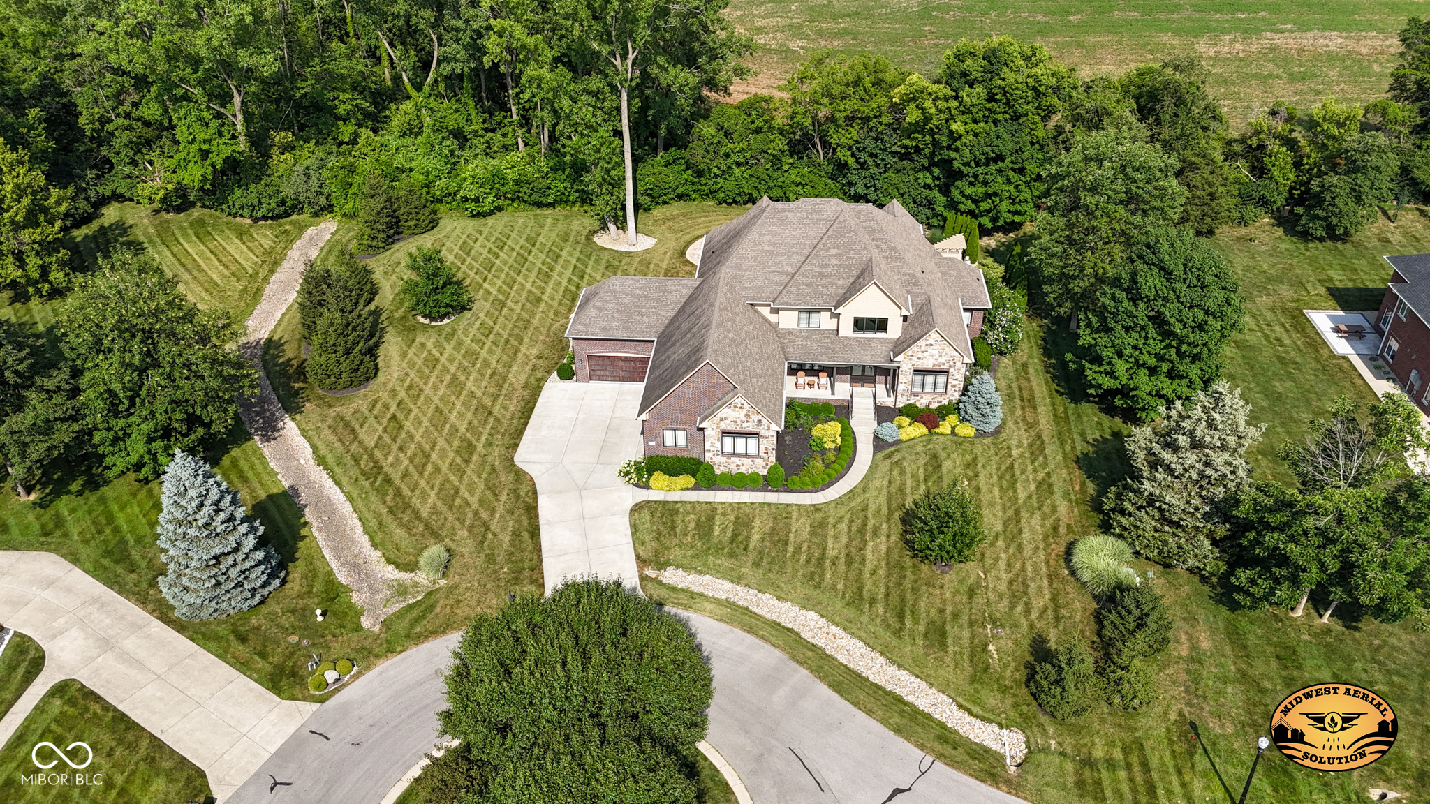 This absolutely exquisite luxury home is nestled in the prestigious private and gated Persimmon Woods neighborhood. The quality and craftmanship is apparent throughout, with 5 bedrooms (all with attached bathrooms), gourmet kitchen, full finished basement, gorgeous lot, inground pool, and 4 car garage, there is nothing left to be desired. The home opens into a two-story foyer with views of the large dining room and great room with views straight out to the sparkling pool and private lot with mature trees!  The home office, off the foyer, is truly the best, with $55K in updates in the last year (gorgeous built-in cabinets and granite counters).  Moving from the front through the dining and living area and into the beautiful kitchen, the pride-in-ownership is evident with detailed trim work, built-in bookshelves and arched doorways. The chef's kitchen does not disappoint, with endless cabinets and granite counter space, gas range and hood, double built-in ovens and a large pantry.  The large main floor primary bedroom is the perfect retreat, with patio access, attached bath featuring double vanities, garden tub with separate shower, and mammoth walk-in closet. The main floor is finished out with incredible mud room space, entered into from both garages, with half bath, access to the laundry, and plenty of storage space. Upstairs you'll find three well appointed bedrooms, all with attached bathrooms and large bonus room, perfect for gaming or movies!  The finished basement with daylight windows provides all the space needed with the same level of quality as the rest of the house - living area, game area, bar, large bedroom with attached nook and full bathroom, exercise room, and plenty of storage!!  The large tree-lined lot provides plenty of privacy, and plenty of opportunities for fun with the inground pool, hot tub, covered patio and open grass areas!!  This home is truly incredible and should not be missed!!!