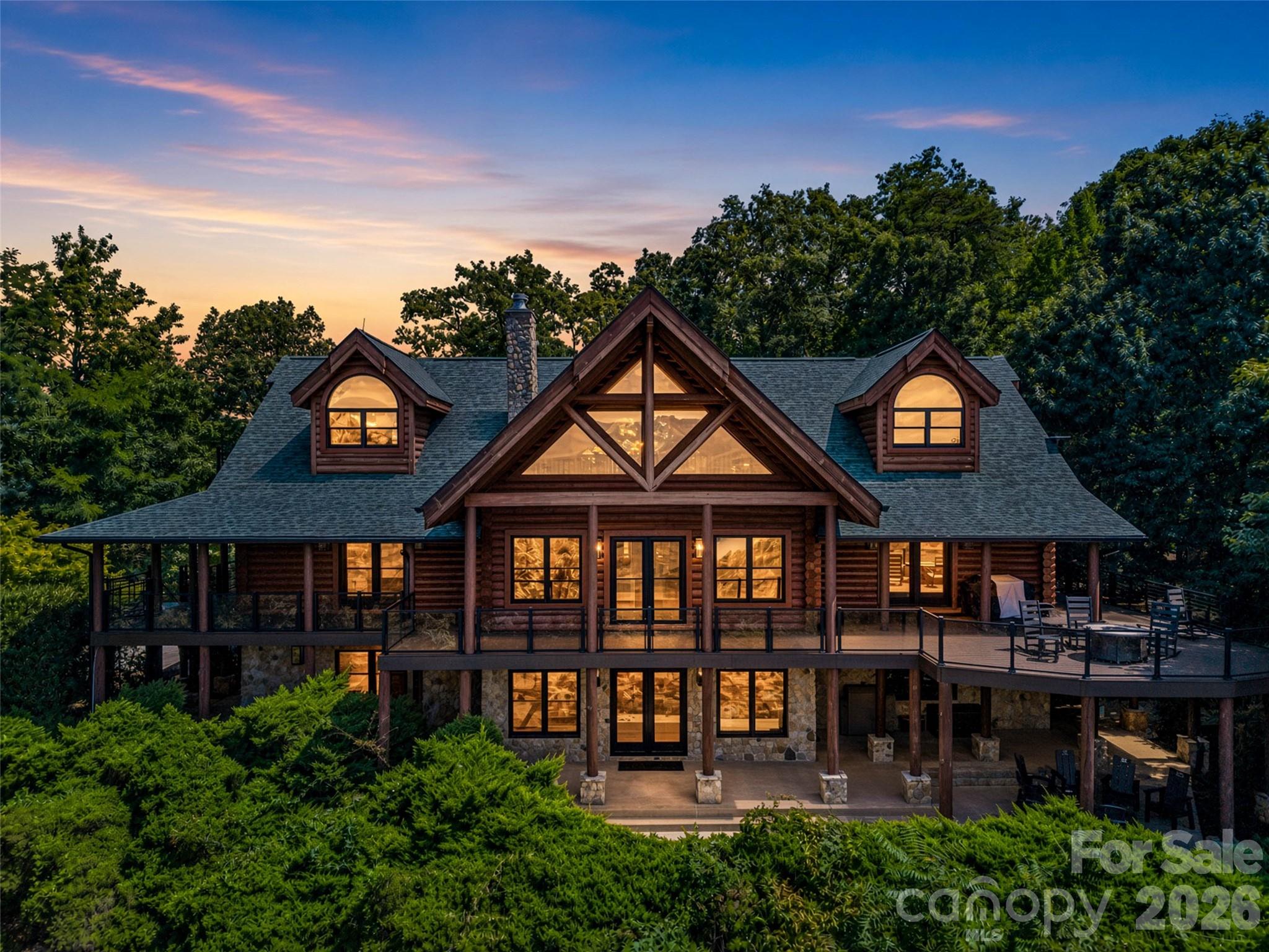 Perched at the very top of The Ridge in Shumont Estates, this extraordinary 7,000+ square foot log estate offers one of the most breathtaking views in all of Lake Lure. With panoramic year-round mountain views and the sparkling waters of Lake Lure stretching out below, every window feels like a masterpiece. Built to impress and engineered to last, this home features 10-inch tongue-and-groove logs, poured concrete walls reinforced with steel, massive steel I-beams for exceptional structural integrity, and even a lightning suppression system. Inside, every detail speaks to elevated mountain living. Every bedroom has its own luxurious en-suite, complete with walk-in closets and unforgettable views. Additional highlights include an 800+ bottle wine cellar, recreation room, media room, paved circular driveway with abundant parking, whole-home Generac generator with dual underground fuel tanks, all-new HVAC systems, new doors and windows throughout, and expansive Trex decking complete with glass railings and integrated lighting to maximize the incredible views. Privately tucked away on over 3 acres at the end of a quiet cul-de-sac, this is mountain luxury at its finest. As part of the Rumbling Bald community, you will enjoy exclusive access to a private beach, Lake Lure access, indoor and outdoor pools, championship golf, tennis, fitness center, spa, restaurants, a Starbucks on site and so much more. This isn't simply a home. It's a rare opportunity to own one of Lake Lure's most iconic mountaintop retreats.