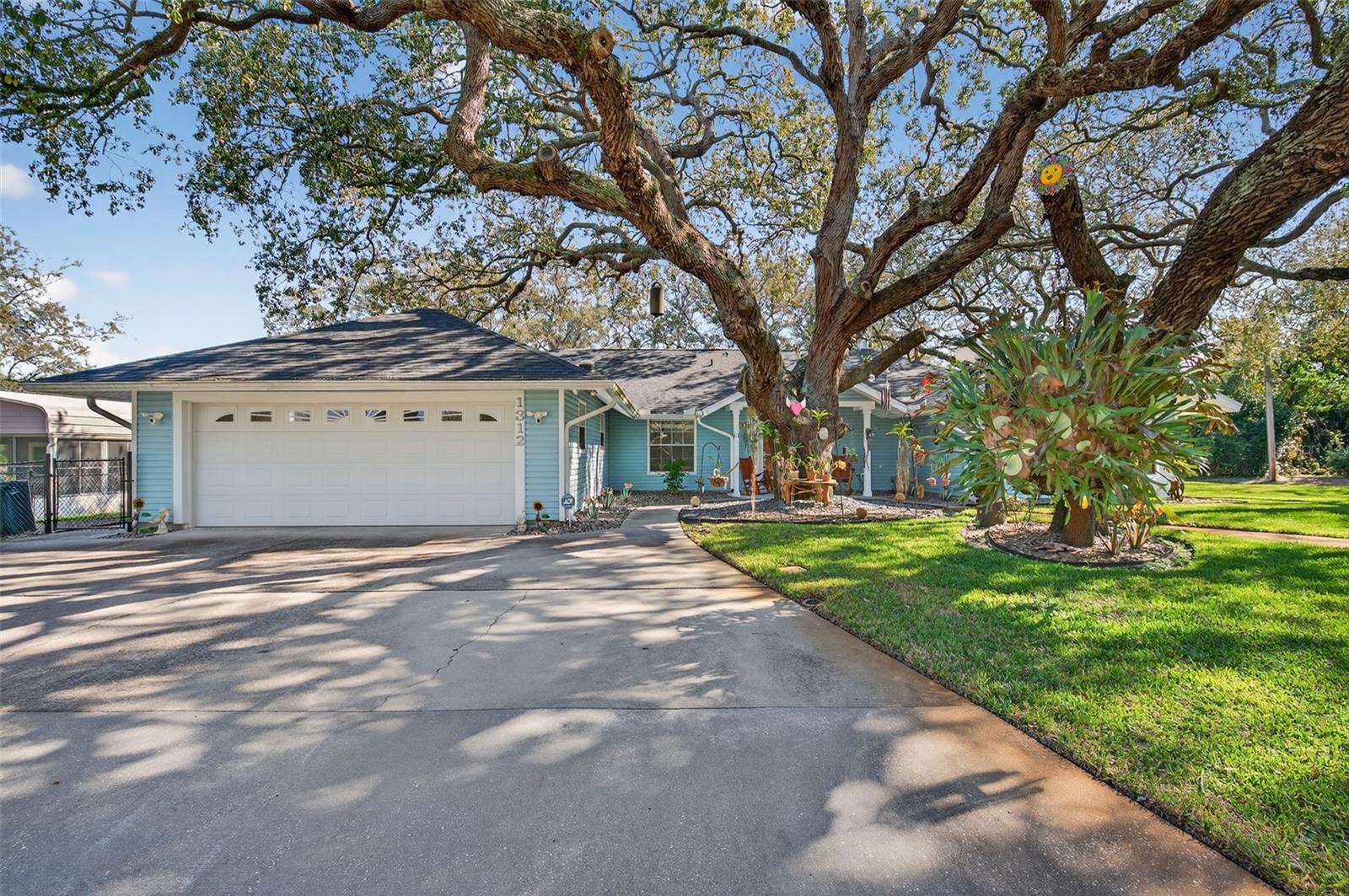 Back on the Market! This time home only. Beautifully Maintained Under Majestic Oaks. Discover the peaceful charm of country living without sacrificing convenience in this well-maintained over 2100 square ft 3-bedroom, 2-bath home with a 2-car garage. Situated on a high and dry in Unincorporated Tarpon, not in city limits (not in a flood zone),*NO HOA, this property is surrounded by towering mature oak trees that create a serene, natural canopy with the feeling of being tucked away in the countryside. This Home Features 3 spacious bedrooms 2 full baths *NEW ROOF 2025, *AC 2020,* Water Heater 2020, *New Bosch Dishwasher 2025, *New Luxury Vinyl Flooring 2021, *New Plantation Shutters 2023, *Washer 2026 Dryer 2023,* Replaced water lines in attic 2024,Gorgeous Cedar Plank Ceilings. *Solar tube 2025. Bright, open living areas with beautiful views of the surrounding oaks Immaculately maintained interior and exterior fully fenced with gutters and security ring cameras, doorbell and flood lights. *Freshly painted 2-car garage with ample storage, garage door replaced 2017 with hurricane rated door. Generator ready. This homes is on septic and has been freshly pumped March 2026.  As a bonus the rear slab patio has been permitted and has 12 inch footers, to where you can add on to the existing home.  This home is situated on a quiet dead end street, so no through traffic.    High and dry elevation provides peace of mind—no flood zone. These stunning trees provides generous shade from the Florida Sun while offering sense of natural protection and timeless beauty and that true country feel. The home Sits back on a beautiful lot that blends nature, privacy, and comfort. Now is the time for one or all to come see what you've been waiting for. The time is NOW. This is a rare opportunity to own a property with natural beauty, and endless potential—enjoy a tranquil, tree-lined setting. Local to area beaches, marina's and down town areas that host a multitude of cultural events and community gatherings. Airports-Concert Venues- Theatre and Sporting Arenas are all within 45 minute drive times. This is a must see on your tour of homes!