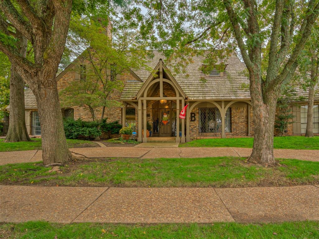 Timeless Tudor Revival in Whispering Pines on the west side of OU’s campus. This 4-bedroom with an optional 5th bedroom, 3.1-bath home offers 4,662 sq. ft. of beautifully crafted living space on a corner lot. Grand ceilings and walls of windows fill the home with natural light, while rich wood details and a wine cellar add warmth and charm. The gourmet kitchenboasts custom cabinetry, premium stainless appliances, and a built-in pizza oven (a favorite) — perfect for entertaining. Retreat to the luxurious primary suite with a spa-inspired bath featuring a clawfoot tub, walk-in shower, and generouscloset. Upstairs, a Jack-and-Jill bath connects two of the 3 secondary bedrooms, plus a hidden bunk room offers extra space for guests or play along with a second living room with a beautiful stone fireplace and a wet bar. Enjoy outdoor living around the private pool surrounded by mature trees. The pool has been opened and pool pump was replaced in April 2026. A true blend of old-world character and modern comfort in the heart of Norman.