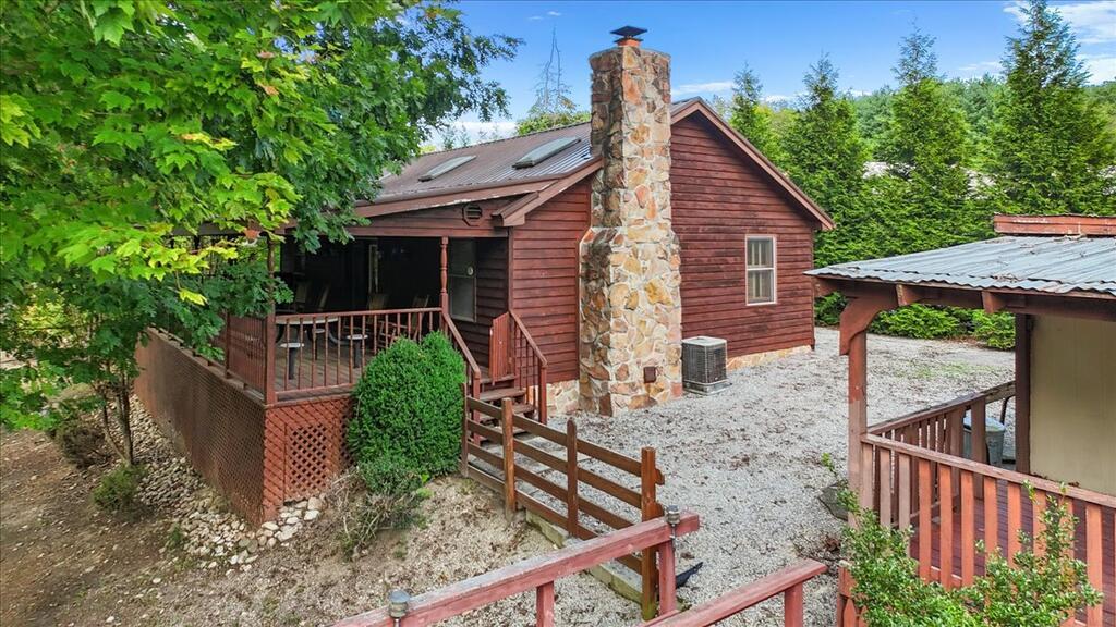 ONE-OF-A-KIND CLAYTOR LAKE WATERFRONT RETREAT on 2 tracts totaling 1.4617 acres, across from the public boat launch! Boat lift w/Jet Ski drive-on & deck above. Contemporary home built in 1995 offers a vaulted Great Room w/fireplace, Kitchen w/3 skylights, Dining Area w/hardwood floors, 2 BR, 2 BA & laundry. Upstairs sitting area + 2 attic storage areas. PLUS original 1BR/1BA cabin w/Kitchen & antique stove/refrigerator AND camper w/Kitchen, Living/Dining, 1BR/1BA. Combined: 4 BR, 4 BA & approx. 1,905 SF per Matterport. LARGE covered decks on house, cabin & camper! Tall garage/workshop, locked 3-stall garage for boats/Jet Skis/vehicles, carport, storage building & wood shed. NEW insulation & underpinning on main house. Most furniture, window treatments & personal property convey. Paddle boat & firewood convey. Heat pump in house; EBB heat in cabin/camper. Extensive documents in MLS. BRING YOUR CLOTHES & FOOD—START ENJOYING THE LAKE! 5 Min from I-81 & 5 Min to Claytor Lake State Park.