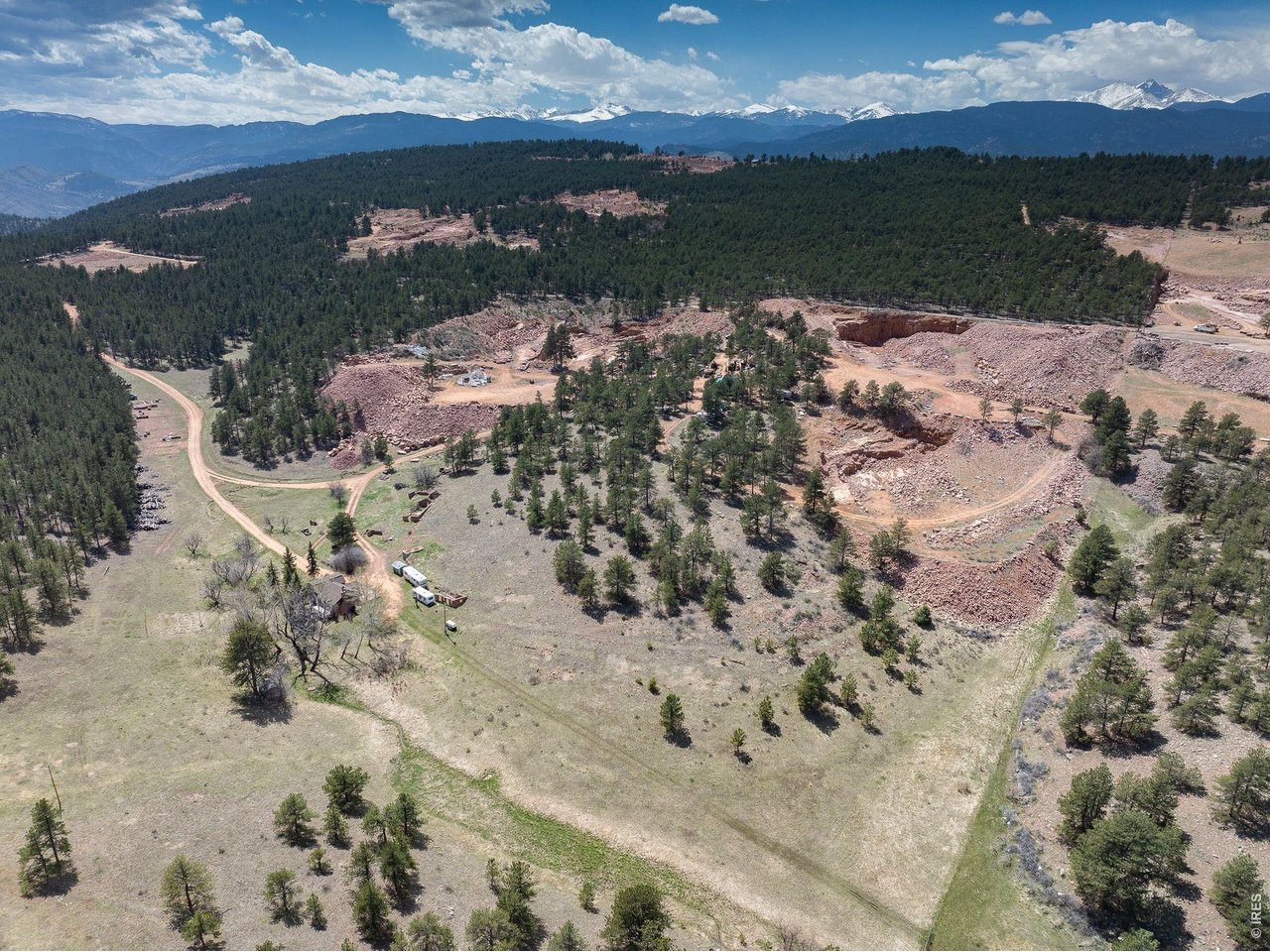Five miles north of downtown Lyons, 44.39 acres carry a story most Boulder County land cannot tell. This is the heart of the original 300-acre Ohline Ranch, held and worked for generations, and offered now as a rare piece of Colorado with real optionality.A private drive winds through Ponderosa pine to the Ohline homestead, a thoughtfully updated 2-bedroom, 1-bath residence of 1,403 square feet with hardwood floors, original stonework, and indoor-outdoor living that feels both rooted and refined. A seasonal stream, working apple orchard, and period outbuildings anchor a setting that lives larger than its footprint.There is also a meaningful path to expand the property's residential value. Pursuing historical landmark designation for the homestead could unlock a second primary residential building site and reclassify the existing home as an ADU, creating a two-residence legacy compound on a single parcel.The remainder of the land is where the property becomes singular. Roughly 25 acres are permitted for sandstone extraction under an active Colorado 112c mining permit, with a 2005 mineral study identifying reserves in the millions of tons and infrastructure in place for dimensional block, slab, and crushed stone. A turnkey income asset attached to a residence, almost impossible to replicate in today's Front Range land market.For buyers thinking wider, 1312 Steamboat Valley rewards imagination. A legacy land holding. A creative or craft compound. A private equestrian retreat. A phased-use strategy balancing residence, income, and conservation. Few Boulder County properties let a buyer choose their own thesis. This one does.Lyons in minutes, Longmont in twenty, Boulder in thirty, Rocky Mountain National Park within an hour. Canyon-edge privacy, dark skies, and a setting that feels genuinely removed without being remote.