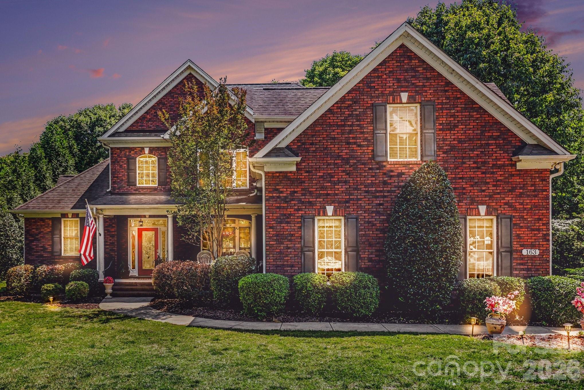 Welcome to 163 Evening Shadow Road — where timeless craftsmanship, luxury upgrades, and everyday functionality come together on a beautifully manicured one-acre lot in the heart of Lake Wylie. This full brick custom home offers the rare combination of privacy, elegance, and convenience with no HOA and an exceptional layout designed for both entertaining and comfortable daily living.From the moment you arrive, the home’s presence stands out with mature landscaping, expansive frontage, and classic architectural appeal. Inside, soaring ceilings and a stunning two-story great room create an impressive first impression while still feeling warm and inviting. Rich oak hardwood flooring, updated luxury finishes, and thoughtfully renovated spaces elevate the home throughout.The layout is one of this home’s strongest features. The kitchen serves as the true heart of the home, positioned perfectly between two separate living spaces to create exceptional flow for entertaining, gathering, or simply spreading out comfortably. Easy access to the rear deck extends the living space outdoors, creating an ideal setup for hosting guests, enjoying quiet evenings, or taking in the peaceful surroundings of the fenced backyard and private lot.The spacious primary suite on the main level offers a true retreat with updated bathrooms and refined finishes that bring both comfort and sophistication. Upstairs, additional bedrooms and flexible living space provide room for family, guests, home offices, or recreation.Luxury details throughout the home include rare Brazilian countertops, updated fireplace surrounds, modernized bathrooms, upgraded lighting, and designer touches that make the property feel elevated yet livable. Recent updates including fresh paint and carpeting further enhance the move-in-ready appeal.Beyond the beauty of the home itself, the property offers a lifestyle that is increasingly difficult to find in the Lake Wylie market — a private one-acre setting without HOA restrictions while still being conveniently located near Lake Wylie amenities, Clover schools, shopping, dining, and quick access into Charlotte.Homes with this level of space, privacy, functionality, and tasteful updates rarely become available. This is more than a home — it is a property designed to live beautifully for years to come