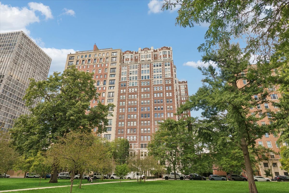 Nestled within one of East Lincoln Park's classic pre-war buildings, this lovely updated apartment offers the grace and scale of a private home. A semi-private elevator landing, shared with only one other residence, opens to a dramatic entry foyer with a groin vault ceiling, setting a tone of architectural distinction. The grandly scaled living room is a showcase of timeless design, anchored by its original fireplace mantle and framed by intricate crown molding and classic shutters. Entertain with ease in the well-proportioned formal dining room, a versatile space that could also serve as a comfortable den or library. The well-appointed kitchen seamlessly blends vintage charm with modern luxury, featuring white inset cabinetry extending to the ceiling, sleek Silestone countertops, and a full suite of stainless steel appliances, including a wine cooler. Retreat to the serene bedroom, where a full wall of custom-built-in storage provides effortless organization. The en-suite bath is a study in classic taste, appointed with a marble vanity and timeless subway tile. Modern upgrades include newer windows, SpacePac air conditioning, central humidification, custom closets, and hardwood floors throughout. With bright north and south exposures, this home enjoys lovely natural light and charming glimpses of the lake and park. 2440 N. Lakeview is a premier building offering a 24-hour doorman, a magnificent rooftop deck with grills and skyline views, an exercise room, and dedicated storage.