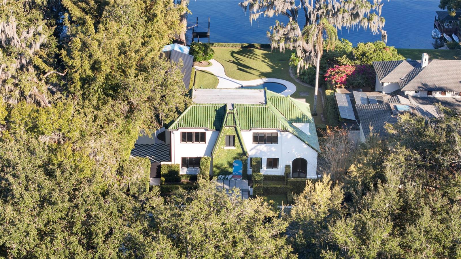 Steeped in history and masterfully reimagined, this 1926 Winter Park estate blends architectural provenance with modern refinement. Thoughtfully restored by E2 Homes, the residence honors its past while offering contemporary sophistication. Unlike many historic properties, it is free from preservation restrictions, allowing for seamless enhancements. On the shores of Lake Virginia along the desirable Winter Park Chain of Lakes, this 3,181-square-foot estate features four bedrooms, three full baths and two half baths, with three bedrooms in the main house plus a detached one-bedroom guest cottage. The second-floor primary suite is a private retreat with a Juliet balcony, dual closets and an elegantly appointed bath with an expansive dual-sink vanity, a separate water closet, and a washroom with a shower-tub combination. A Jack and Jill bath, adorned with Maharam wallpaper, serves the additional upstairs bedrooms. The Poliform Twelve kitchen showcases European craftsmanship with Gaggenau and Sub-Zero appliances, sleek Italian cabinetry and natural basalt countertops. The formal dining room, framed by arched windows and French doors, opens to a vine-covered courtyard, while the sunroom offers uninterrupted lake views. A fireplace in the living room, flanked by custom built-ins, adds warmth to the home’s contemporary aesthetic. Beyond its striking interiors, the estate is an architectural rarity, featuring original woodwork by Gene Leedy, a key figure in the Sarasota School of Architecture. The home is crowned with sought-after Ludowici-Celadon Imperial roof tiles. Poliform built-ins extend throughout, including a dedicated upstairs office/library. An integration of art and architecture, the property features site-specific installations by acclaimed artist Matt Olson. His No Separation project finds a compelling continuation here. The entryway, designed by Olson’s firm OOIEE and inspired by Sol LeWitt, makes a striking first impression. Designed for seamless indoor-outdoor living, the estate’s exterior spaces are as refined as its interiors. A covered deck overlooks a heated saltwater pool. A wood-clad pergola shelters the lanai. The boathouse includes a partial bath, creating a waterfront sanctuary. A Sonos-integrated sound system extends from the main house to the patio, guesthouse and boathouse, ensuring a seamless sensory experience. The detached guesthouse is a private retreat with a full bedroom, bath, kitchenette and Poliform built-ins. Floor-to-ceiling windows frame manicured grounds and lake views, while a private covered porch provides a tranquil space for relaxation. Every detail has been meticulously curated, from designer lighting to motorized roller shades and a wood-burning fireplace anchoring the living room. A private wine library enhances the home’s sophisticated appeal. Meticulously maintained by E2 Concierge services, the residence undergoes routine wellness checks and meticulous upkeep. A distinctive home of this caliber is rarely available, a residence where history, architecture and art converge in harmony. This is a once-in-a-lifetime opportunity to own one of Winter Park’s architecturally and artistically significant properties.