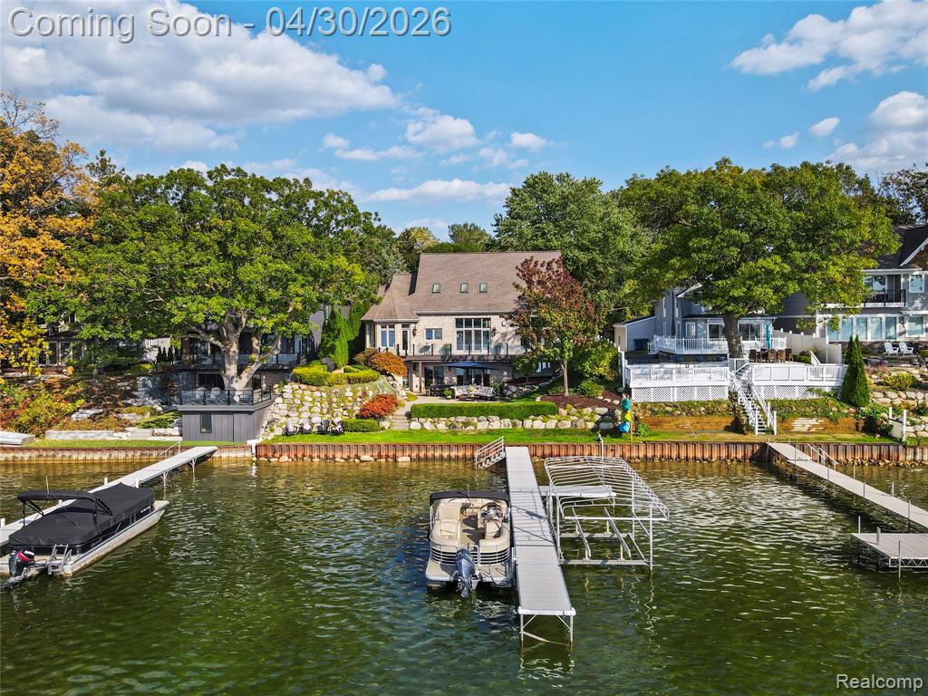 Set on 75 feet of pristine sandy frontage along all-sports Lake Fenton, this exceptional waterfront home offers a lifestyle defined by effortless luxury and a seamless connection to the water. Sunlit living spaces and a thoughtfully designed floor plan flow effortlessly to a new Trex deck, while the first-floor primary suite provides a private retreat with direct access—perfect for quiet mornings and year-round sunset views. The lower level is designed for entertaining, featuring heated floors, a full second kitchen, and a full bath with a spa-inspired steam shower. A 5-car garage built in 2022 with a half bath is complemented by a fully appointed guest suite above, offering an additional 1,100 sq ft of living space complete with a quartz kitchen, living area, laundry, and a walk-in shower—ideal for guests or extended stays. A brand-new seawall (2025) and a spacious backyard complete this rare lakefront opportunity. An extensive list of updates and features is available upon request through the listing agent. Includes Parcel ID #06-11-529-065 (.09 acres), bringing total acreage to .32. Pre-approval or proof of funds required prior to showing — NO EXCEPTIONS.