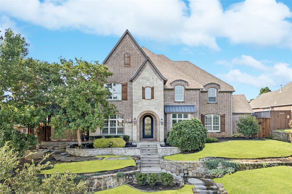 Beautifully designed with remarkable attention to detail, this Castle Hills home offers over 5,300 square feet of living space on a landscaped 0.325-acre lot. The flexible floor plan includes five bedrooms plus a private office, elegant dining areas, a spacious game room, and a fully equipped media room. The gourmet kitchen is the centerpiece of the home with built-in refrigerator, commercial-grade range, double ovens, expansive island, and walk-in pantry. It flows seamlessly into the family room with stone fireplace and views of the backyard. The primary suite on the main level is a private retreat featuring dual vanities, soaking tub, separate shower, and a generous walk-in closets with secondary washer and dryer connections. Highlights include hardwood and stone floors, wainscoting, decorative lighting, granite counters, multiple staircases, and a 3-car garage with alley access. Smart wiring, built-ins, and abundant storage add to the home’s functionality. Outdoor living is exceptional with a sparkling pool, outdoor shower, covered patio, built-in grill, and full outdoor living center—perfect for entertaining or relaxing. The landscaped yard offers privacy and plenty of space to enjoy year-round. Located in the desirable Castle Hills community, residents enjoy access to walking trails, lakes, parks, golf, tennis, and a vibrant town center with shops and dining. Zoned to Lewisville ISD schools, this property combines luxury, comfort, and convenience in one of North Texas’ premier neighborhoods.