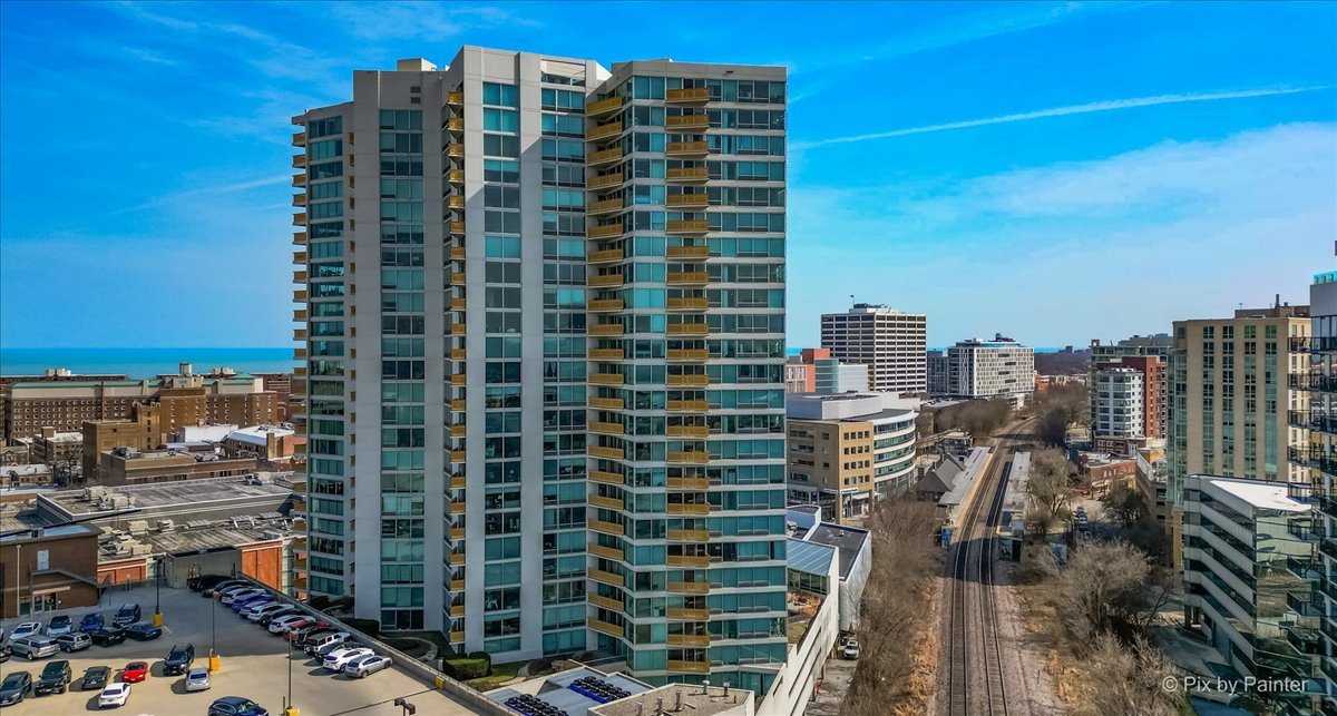Experience panoramic lake views from this spacious 1-bedroom condo in Downtown Evanston. Floor-to-ceiling windows flood the interior with natural light, complemented by a private balcony and a spacious open floor plan. The unit is designed for modern comfort, featuring an extra-wide living area and a contemporary open kitchen equipped with granite countertops and a breakfast nook. Additional highlights include a large bedroom with a walk-in closet, the convenience of in-unit laundry, and heated indoor parking. The building offers premium amenities, including a 24-hour doorman, an indoor pool, and an exercise room. It is conveniently located within walking distance of dining, Whole Foods, Trader Joe's, and the Metra/Purple Line transit hubs. **New Refrigerator (Installed 02/2026), Vinyl Plank Flooring throughout living areas, bedroom, and foyer (Upgraded 07/2024) Programmable Thermostat for enhanced energy efficiency (New 07/2024)