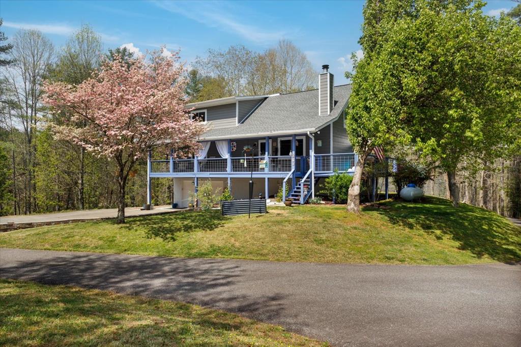 Tucked away in your own private slice of mountain paradise, this beautifully upgraded 3-bedroom, 2-bath, fully-furnished home offers the perfect blend of comfort, style, and serenity. From the moment you arrive, you'll appreciate the peaceful setting, complete with a pretty mountain view, and flowering trees and azaleas, that creates the ideal backdrop for everyday living.  Inside, you'll find tons of upgrades throughout- including a whole house generator- thoughtfully designed to enhance both function and charm. The spacious layout flows effortlessly, making it perfect for relaxing evenings or entertaining guests. An attached garage adds everyday convenience, while the separate storage buildings provide plenty of room for tools, hobbies, or outdoor gear.  Whether you're sipping your morning coffee while soaking in the view or enjoying the quiet privacy this property offers, this home truly feels like a retreat—yet still close to everything you need. ***List of upgrades to this home include*** New water heater, new windows, new granite countertops, new appliances, new LVP flooring and new carpet, roof replaced in 2020, garage door and opener replaced in 2019, new wood on side deck and back stairs, new lighting, new plumbing fixtures, A/C unit is still under warranty, new kitchen cabinet doors and pantry doors, upstairs closet is cedar lined... and the list goes on! This beautiful home is a must see!!