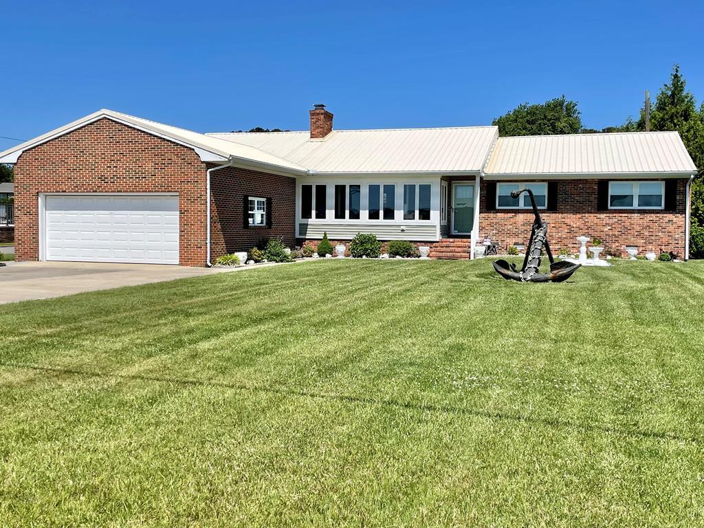 A RARE OPPORTUNITY! Looking for views of the Lighthouse? Here is it! Well maintained home and the waterfront parcel across the street with dock. Fish & kayak from your own yard! Come into the home to the living room that opens up to the front sunroom, ideal for watching the boats on the Channel & lighthouse. Nice size dining room. Large kitchen leads into laundry room with back door or into the family room with garage entrance. North side of home offers a full bath, primary bedroom with full bath and an additional bedroom. Concrete drive, large garage, shed and lovely landscaping. 2017 NEW metal roof. 2021: Floor in living room was raised as well as new laminate flooring installed in living room, sunroom & dining room & new appliances! A must see home! Most furnishings to convey. Big shed.