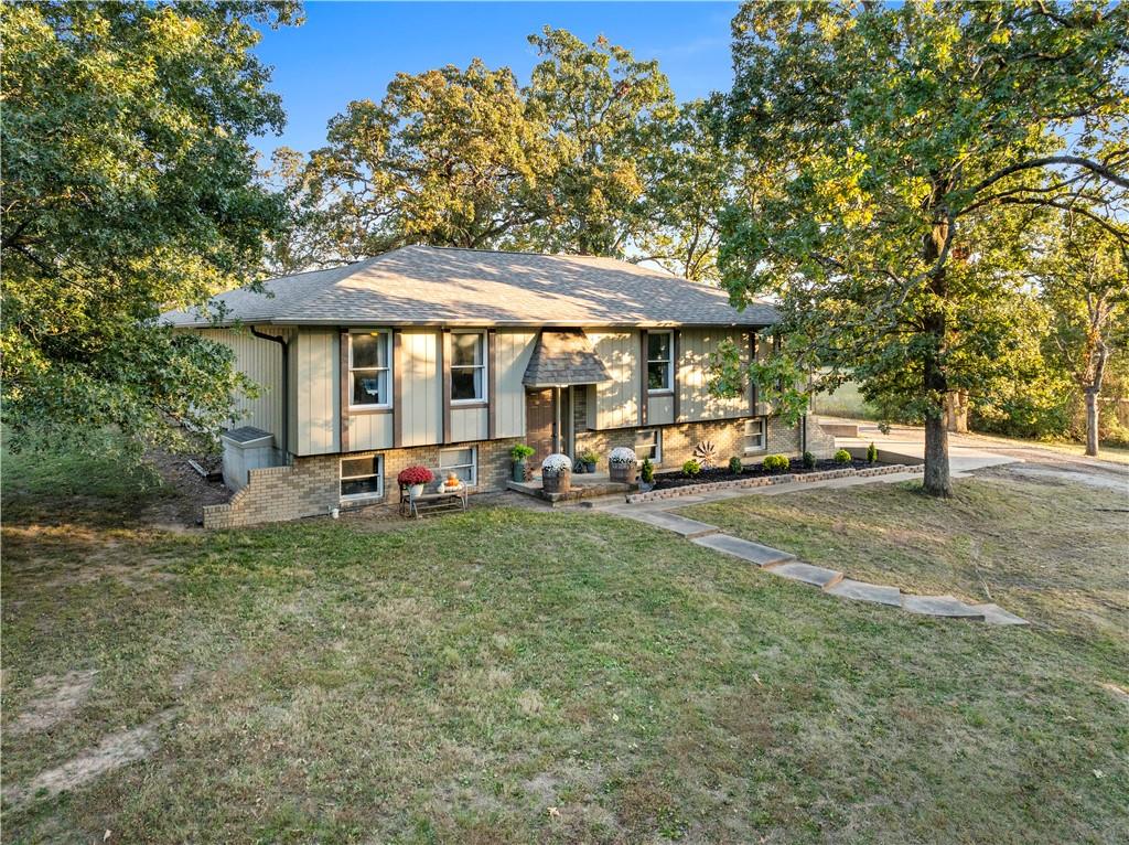 Escape to the quiet countryside with this beautifully renovated 4-bedroom, 3-bathroom home situated on nearly 2.5 acres just south of Nevada, MO. Resting at the end of a long, private driveway that is beautifully framed by mature trees, you will love the feeling of seclusion while still having the convenience of living just minutes from town. Nearly every detail is new, including the roofing, gutters, flooring, fresh paint, and fixtures. The inside of the home is thoughtfully laid-out and provides generous space and a bright, open feel. The main floor includes a spacious kitchen and dining area, living room, hall bath, and 3 bedrooms, including the primary suite. Downstairs, the versatile lower level offers an additional living room that could be perfect for a media room, home office or gym, or a separate hang-out spot. The lower level also includes 1 bedroom and 1 full bathroom, perfect for a private guest area or multi-level living. Beyond the stunning interior, this property offers excellent utility for country living and ample space for relaxation. Enjoy the outdoors on the covered back patio, which provides great outdoor entertainment space and could easily have screens or windows installed to create a sunroom or enclosed porch. Park your vehicles with ease in the oversized 2-car attached garage or utilize the additional covered parking available at the back of the house. For those needing extra storage or a dedicated workspace, there is also a detached garage/shop on the property. Don't miss your chance to own this updated home outside city limits, call to schedule your private tour today!