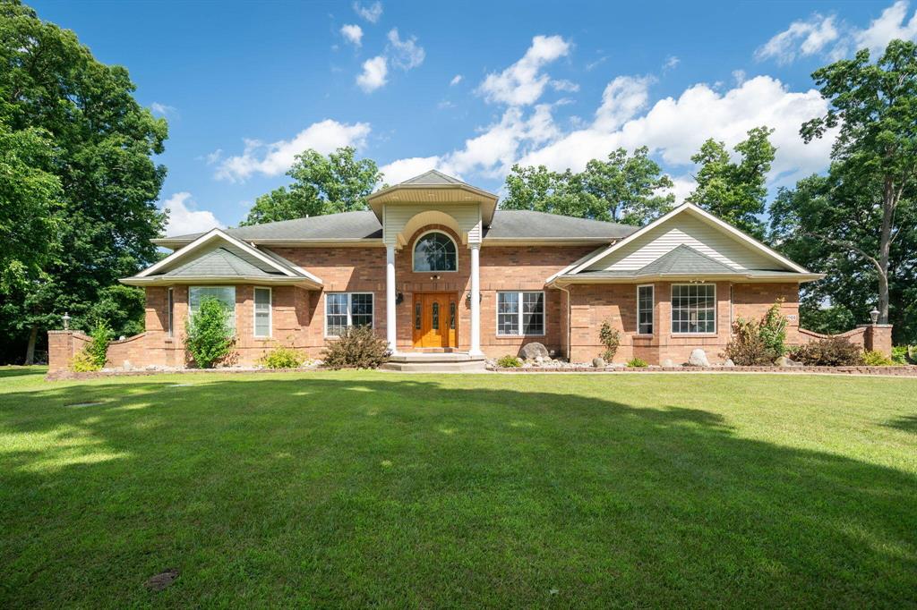 Napoleon the Chihuahua says: ''WOW! WOW! WOW!'' This custom-built brick home with a three stall garage, is wow through out! From the great room entry featuring vaulted ceilings and a wide grand oak staircase, pass through the arch way to the  kitchen or the dining and living rooms. The master suite and a second bedroom connected to a full bath, complete the main floor. Upstairs, there are two bedrooms each  with private bathrooms, and an office area. The finished basement has three  bedrooms, and a full bath, rec room, office, and plenty of storage. Outside, there is a large 20' x 20' deck, a 32' x 48' pole barn, which will be finished, and 34 acres of land, which used to be a farm and a forest, to roam, hunt,  and enjoy the wildlife.