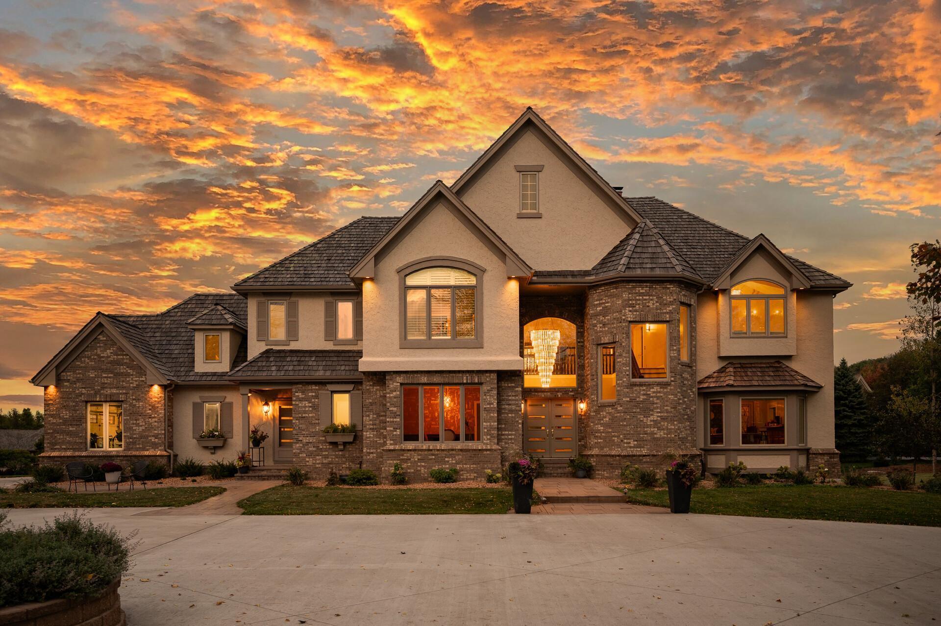 Welcome to this stunning 5-bedroom, 7-bathroom luxury home set on a private 2+ acre lot in the highly sought-after Tuckborough Farms community. A circular driveway and stamped concrete walkways lead to the impressive brick-and-stone exterior. Inside, the grand foyer showcases soaring 18-foot ceilings, a statement chandelier, and marble floors throughout the main level. The dramatic family room features floor-to-ceiling windows, a double-sided electric fireplace with marble surround and custom shelving, and breathtaking backyard views. The chef’s kitchen offers quartz and marble countertops, an expansive center island with breakfast bar seating, soft-close cabinetry, stainless steel appliances, and a high-end Wolf range and oven. The kitchen flows seamlessly into the informal dining area, sunroom, and expansive deck—ideal for indoor-outdoor entertaining. The main level also includes a formal dining room, private office with shared fireplace, elegant living room, two half bathrooms, laundry room, mudroom with cubbies, and access to the three-car garage with storage and workspace. Upstairs, the luxurious primary suite features double doors, tray ceilings, marble flooring, an electric fireplace, two walk-in closets with built-ins, and a spa-like bathroom with soaking tub, walk-in shower, and double vanity. Three additional bedrooms, a Jack-and-Jill bath, bonus room, and full bathroom complete the upper level. The walkout lower level is an entertainer’s dream with a spacious family room, sitting area with double-sided fireplace, wet bar, exercise room with private bath, recreation room, fifth bedroom, and additional bath. Step outside to the exceptional backyard featuring a fully fenced in-ground heated pool, patio, expansive deck, fire pit area, and open green space. This remarkable property offers high-end finishes, thoughtful design, and exceptional indoor and outdoor living in a premier location.