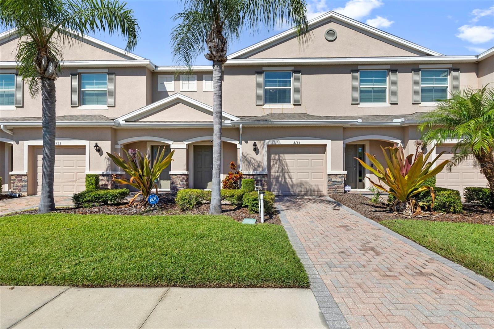 Step into a lifestyle of elegance and ease in this beautifully appointed original-owner townhome in the highly sought-after Seven Oaks community of Wesley Chapel, where refined design and modern comfort meet resort-style living. Meticulously cared for since day one, this home radiates pride of ownership and thoughtful attention to detail.

The property captivates from the start with its paver driveway, tasteful exterior lighting, and lush tropical landscaping. Stone-accented pillars frame the entryway, adding architectural depth and timeless curb appeal. Upon entering, soft natural light cascades through the space, creating a bright and airy welcome. Crown molding flows gracefully throughout, adding a refined finishing touch. The foyer offers the perfect nook for a cozy seating area or decorative console, setting the tone for the warmth that continues within.

Just off the foyer is access to the one-car garage with epoxy-coated flooring—both stylish and practical. Down the hallway, a half bathroom features a solid wood vanity and modern fixtures, seamlessly blending function and design.

The home opens into a spacious open-concept living area designed for both relaxation and entertaining. The living room invites you to unwind, with large windows framing serene pond views and space for your favorite furnishings. Adjacent to the living area, the gourmet kitchen showcases solid wood cabinetry, granite countertops, recessed lighting, stainless steel appliances, a pantry, and a breakfast bar ideal for casual dining. Beyond the kitchen, the dinette area is bathed in natural light through sliding glass doors, offering a tranquil pond backdrop—perfect for intimate meals or quiet mornings.

Upstairs, the laundry closet with shelving is conveniently located near all three bedrooms. The two secondary bedrooms are spacious and versatile, each with generous closet space. The full guest bathroom features solid wood cabinetry, sleek fixtures, and a combination tub and shower.

The primary suite is an expansive retreat with a large walk-in closet and a spa-like en-suite bathroom featuring a dual-sink vanity, frameless glass walk-in shower, and modern finishes. Step outside to the covered and screened rear patio, where you can unwind and enjoy peaceful pond views—a perfect spot for morning coffee or evening relaxation.

Notable updates include luxury vinyl flooring throughout the upper level and a newer water heater. The original owner’s dedication to maintenance ensures this home is move-in ready and thoughtfully preserved.

The HOA covers water, sewer, trash, exterior maintenance, grounds care, and exterior repairs, pest control, exterior painting & roof maintenance offering a low-maintenance lifestyle. Seven Oaks provides true resort-style amenities including multiple pools, a Junior-Olympic lap pool with waterslide, splash park, tennis, volleyball, and basketball courts, sports fields, and a clubhouse with fitness center, theater, and café.

Ideally located near The Shops at Wiregrass, Tampa Premium Outlets, AdventHealth Wesley Chapel, and BayCare Wesley Chapel, this home offers both luxury and convenience.

This isn’t just a house—it’s a place to call home. Schedule your private tour today and experience the exceptional comfort, care, and lifestyle that await you in Seven Oaks.