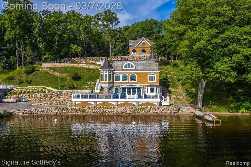 Discover the unparalleled serenity of Treasure Island, an exquisite 80-acre private island where your dream home or family compound stands as the sole residence. Nestled between the tranquil waters of Halfmoon Lake and Blind Lake, this idyllic retreat offers ultimate privacy amid abundant natural beauty, with elevated, breathtaking views from a charming Nantucket-style main home and a luxurious guest/boat house.Step inside to a crisp, airy interior featuring gorgeous white custom cabinetry, elegant wainscoting, granite countertops, state-of-the-art appliances, and stylish tiled backsplashes and floors. The open main floor plan is flooded with natural light through numerous door walls and windows, perfectly framing the picturesque surroundings. The en-suite master retreat includes a cozy sitting area, a full bath with a classic clawfoot tub, a spacious tiled shower, and beautifully tiled floors and walls. The boat house is a masterpiece, complete with a hoist and first-class woodworking. Above, the guest quarters boast a convenient kitchenette, comfortable sitting room, outdoor shower, and stunning barreled wood ceilings that extend to a covered balcony. Outdoors, enjoy a wrap-around deck with see-through glass panels, multiple patio areas, a year-round permanent dock/pier, and professionally landscaped grounds. An oversized 6-car garage provides ample storage, with a large bonus space above ideal for an apartment. Conveniently located just outside of Ann Arbor, this property makes the perfect private retreat or family compound, blending seclusion with easy access to urban amenities.