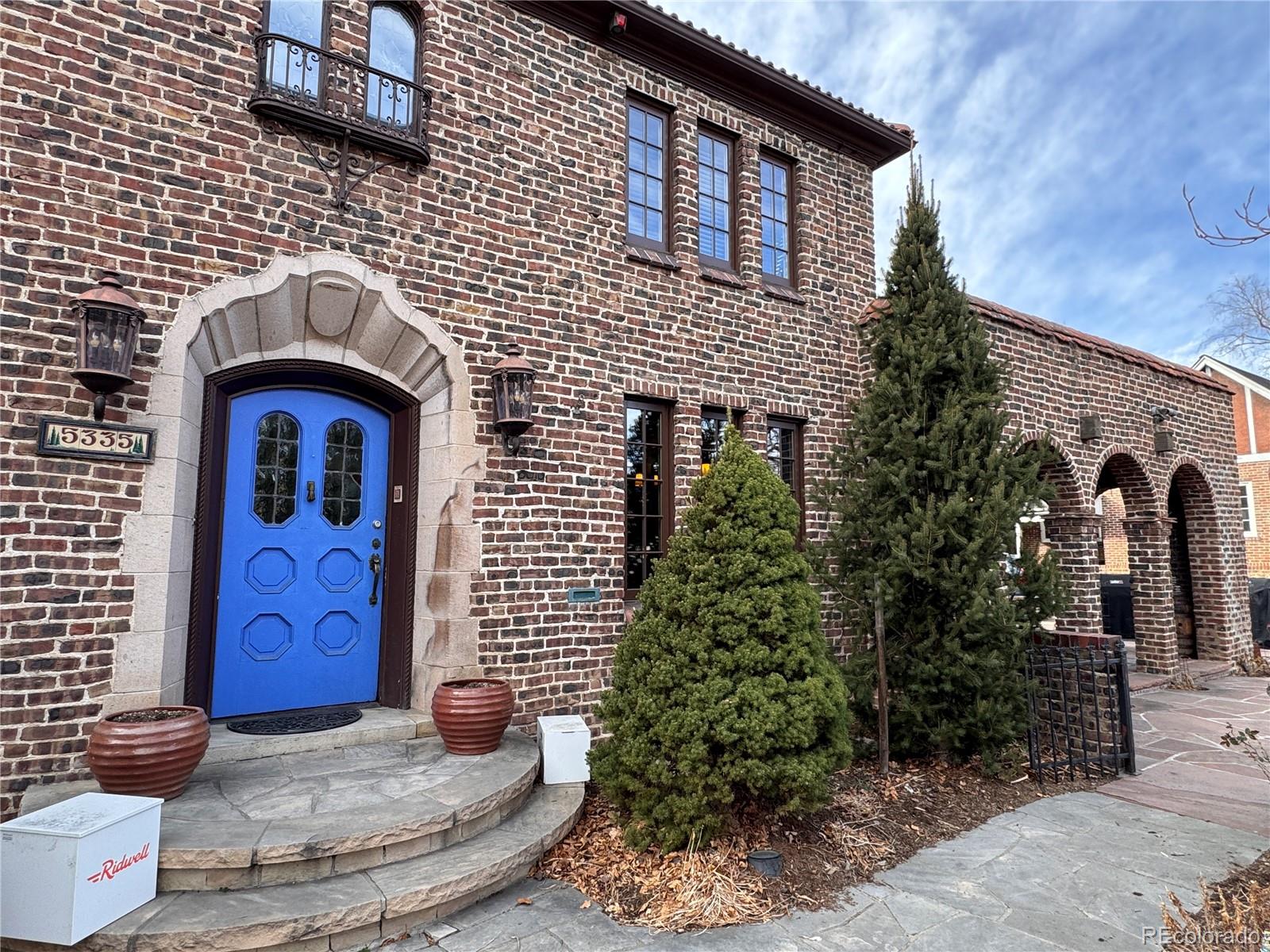 Discover this one-of-a-kind Park Hill residence, where historic charm meets modern luxury. Set amid beautifully landscaped grounds, the home showcases exquisite original brickwork and timeless architectural details. The upper level features five spacious bedrooms and three bathrooms, including a thoughtfully updated primary suite designed for comfort and style. On the main floor, a large sunken living room with a stately fireplace flows into an elegant dining room adorned with leaded glass windows and French doors that open onto a sunny stone veranda—perfect for entertaining or relaxing outdoors. The designer kitchen is a chef’s dream, complete with quartz countertops, shaker-style cabinetry, custom woodwork, beautiful tilework and professional-grade appliances, including a six-burner gas cooktop, vent hood, double ovens, Sub-Zero refrigerator, ice maker, wine fridge and dual sinks. By the entry, a handsome library retains its original wood trim and ceiling beams, leading to private walled courtyard and covered patio—an ideal setting for summer dinners with family and friends. Don’t miss this majestic Park Hill gem, ideally located along one of Denver's most picturesque parkways.