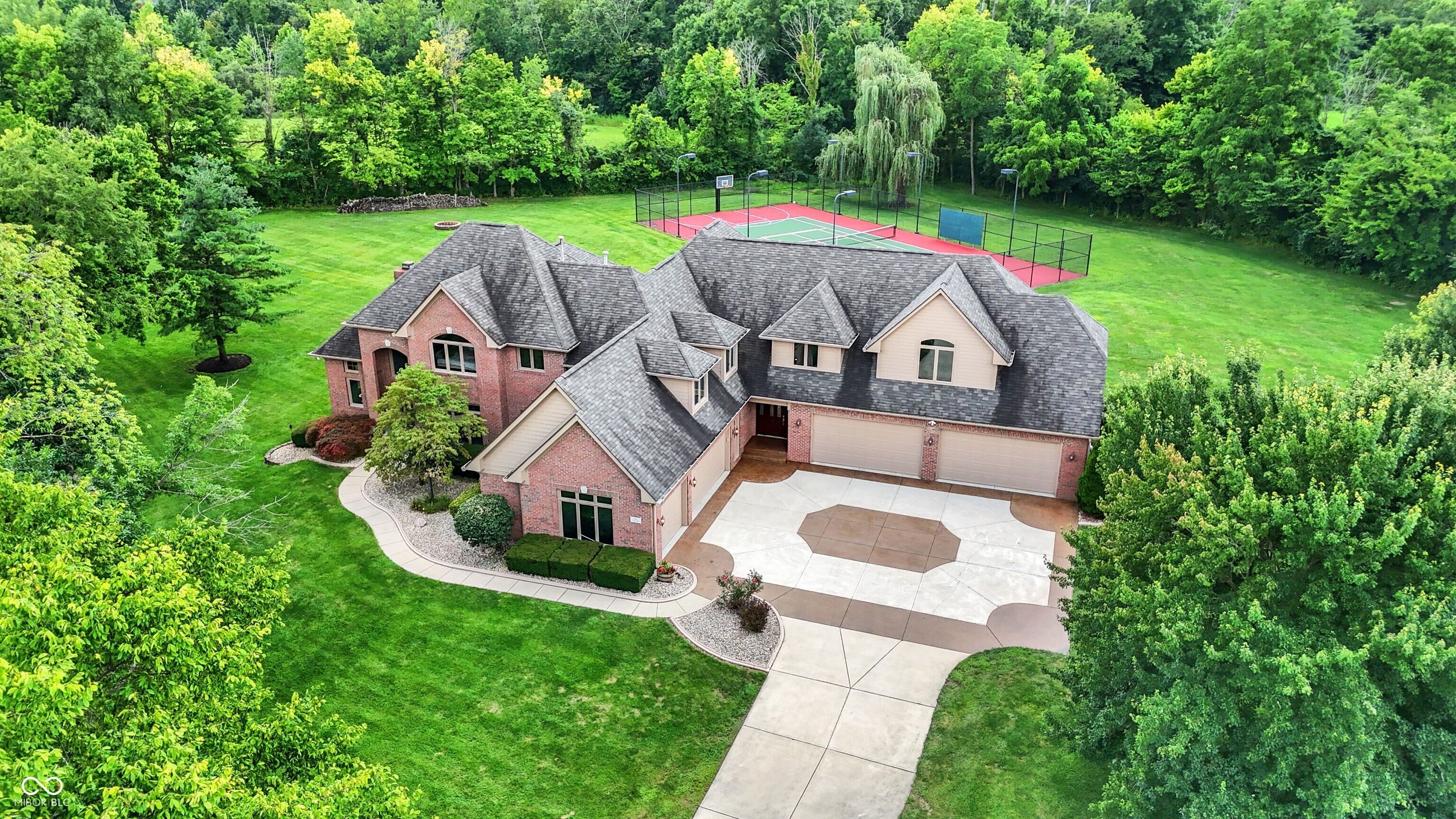 Welcome to this custom-built residence tucked away on 5.52 acres, near the highly sought-after Center Grove Schools. With more than 7,100 square feet of finished living space, this one-of-a-kind property delivers both comfort and functionality in a premier location. Inside, you'll find timeless hardwood floors, spacious living areas, and a thoughtfully designed layout for family and entertaining. The main level features a large kitchen, an expansive great room that brings in a ton of natural light, and a cozy living room with a fireplace. Upstairs, you will find six bedrooms, including four en-suites, brand new carpet, fresh paint throughout, and an office with custom built-ins. The finished basement is perfect for entertaining, featuring a full bar, a pool table, and a family room for movie night or relaxation! Car enthusiasts and hobbyists will appreciate the heated, seven-car attached garage with epoxy floors. Outside, the property continues to impress with mature trees and beautiful landscaping, including a full irrigation system and an invisible fence installed around the perimeter of the entire 5.52 acres. Come enjoy your very own private retreat with a beautiful deck overlooking the grounds, plus the outstanding amenities, including a lighted tennis, pickleball, and basketball courts. This private property is your open space to relax, unwind, and entertain!