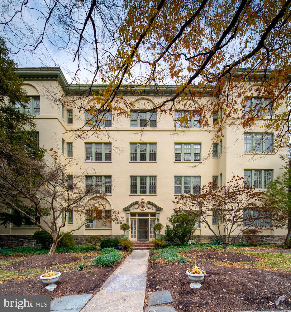 Tucked beneath one of Baltimore’s most beautiful mature tree canopies, Berkeley House stands with the quiet elegance of a 1920s architectural gem—stucco façade, classical detailing, and large multi-pane windows designed to fill each home with natural light. Set in the heart of Tuscany-Canterbury, Unit 2A is a rare residence where history, sunlight, and everyday ease come together just steps from Johns Hopkins, Wyman Park, and the best of north-Baltimore living. Inside, the scale and character of pre-war architecture immediately stand out: soaring ceilings, wide hallways with rich millwork, arched doorways, and the warm glow of 28 restored original windows. With south, east, and west exposures, the home is bright from morning to sunset, offering calming treetop and courtyard views throughout. The gracious living room features original hardwood floors, a decorative fireplace, and a sweeping arched opening into the formal dining room—a window-lined space ideal for entertaining. A corner sunroom, surrounded on all sides by glass, makes a wonderful home office, creative studio, TV room, or potential third bedroom. The kitchen blends classic charm and functionality with tile floors and rich green cabinetry. Two large bedrooms anchor the private wing, each with its own full bath.  Thoughtful updates throughout respect the home’s architectural integrity: preserved hardware, plaster archways, period moldings, and soft, sophisticated color palettes. Berkeley House offers the feel of a private, residential enclave with only eight units, landscaped grounds, and a fenced backyard garden shared by the building. Unit 2A includes a private garage plus two additional outdoor parking spaces—a rare advantage in this highly walkable neighborhood. Unmatched location + lifestyle: • Johns Hopkins Homewood Campus – 2 blocks • Wyman Park – steps away for strolls, jogging, picnics, and wooded paths • Baltimore Museum of Art & Sculpture Garden – 5 minutes • Sherwood Gardens, Loyola, Union Memorial, The Rotunda – all nearby • Neighborhood cafés, culture & convenience: Enjoy coffee at Bird in Hand or On the Hill Café, brunch at Gertrude’s, evenings at Guilford Hall Brewery, and easy access to Charles Village shops, bookstores, and restaurants. Tuscany-Canterbury is known for its peaceful, tree-lined streets, historic architecture, and exceptional walkability. Berkeley House 2A is a home with character, warmth, and history—wrapped in the rare combination of green space, culture, and convenience. A uniquely warm and connected place to call home.