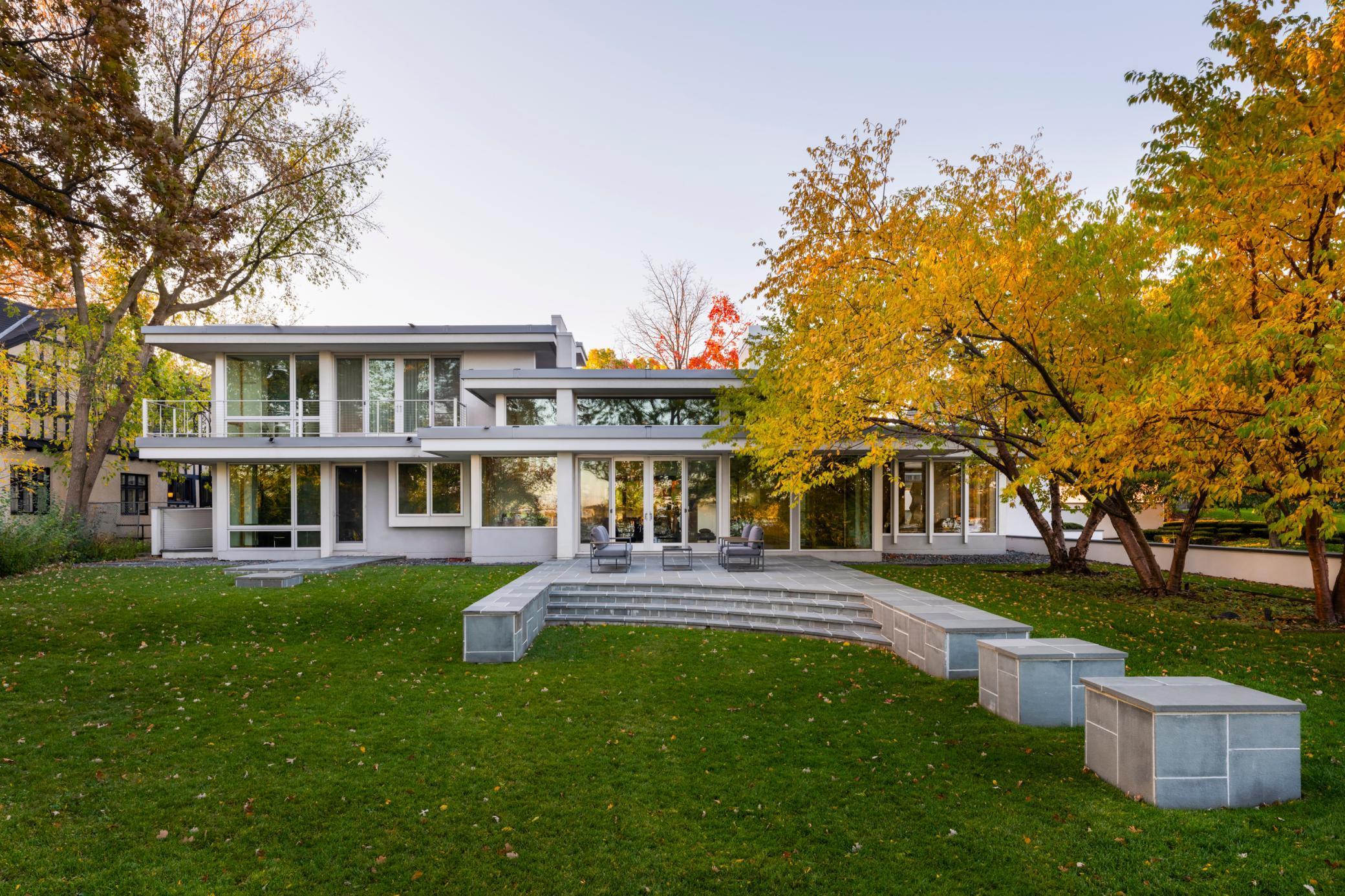 A Lake Harriet Masterpiece of Rare Distinction.  Presenting an extraordinary opportunity to acquire one of Lake Harriet’s most iconic architectural residences—an exceptional collaboration between visionary architect Charles R. Stinson and the renowned craftsmanship of Streeter. Poised gracefully above the shoreline, this sanctuary of modern design commands its setting with quiet confidence and sculptural elegance.Within, the home unfolds as a symphony of light, materiality, and proportion. Vast walls of glass frame the ever-changing landscape, blurring boundaries between interior and nature. Warm Douglas fir millwork, exquisite Australian gum hardwood floors, and meticulously executed details speak to a standard of artistry seldom achieved in residential construction. Every space is composed with intention; every line, a study in modern refinement.The dramatic great room anchors the home—an atmosphere of openness and serenity that extends effortlessly to the professionally designed terraces and a private walled courtyard. This rare outdoor architecture, both intimate and expansive, creates an inspired environment for elevated entertaining, twilight dinners, and moments of quiet retreat.Two adaptable main-level suites—each bathed in natural light—accommodate a range of lifestyle needs, from executive-level workspaces to guest accommodations or private lounges. Their placement within the architectural plan ensures both discretion and connection, offering vistas of the motor court and surrounding gardens.The radiant-heated 4+ car garage connects to a beautifully conceived service corridor, complete with mudroom, laundry, and bespoke pet quarters. A discreet fenced dog run is perfectly integrated along the side of the home, illustrating the residence’s rare fusion of luxury, design intelligence, and daily practicality.Envisioned to evolve with its next steward, the property offers substantial expansion potential on both the lower level and the second floor—providing the opportunity to create additional bedroom suites, a wellness sanctuary, gallery space, or a world-class entertainment level.This is more than a home.It is a legacy—an architectural statement of enduring modernism in one of Minneapolis’ most prestigious lakefront settings, awaiting its next chapter.