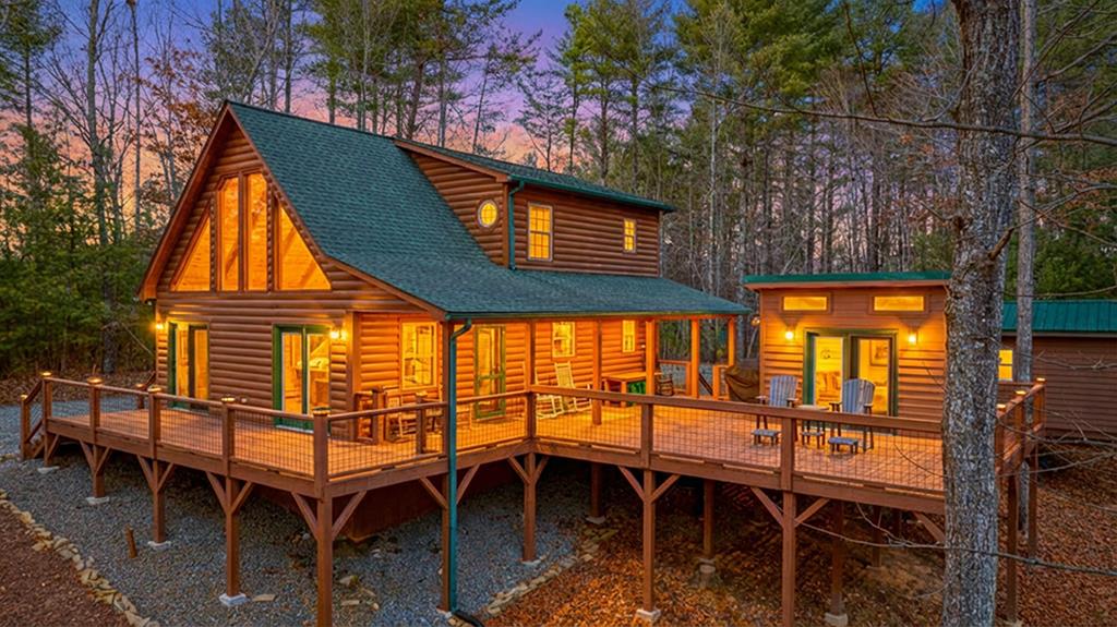 Tucked into the woods just 15 minutes from town and only 5 minutes from the Hanging Dog Recreation Area on Lake Hiwassee, this well-maintained 2-bedroom, 2-bath chalet cabin offers privacy, comfort, and convenience. The open floor plan features a cozy fireplace and abundant natural light, with thoughtfully tinted windows that brighten the space without harsh afternoon glare. It's a mountain home that feels familiar—but stands apart. Inside, the home feels warm and inviting, with a layout that flows easily for everyday living, weekend getaways, or hosting friends and family. The space has a relaxed, comfortable feel that's easy to settle into, whether you're enjoying quiet mornings or winding down after a day outdoors. Step outside to a generous deck—perfect for grilling, relaxing, entertaining, or unwinding after a short commute from the home office or a day spent on the lake. One of the true standouts is the sought-after garden space, something that's surprisingly hard to find in mountain homes and ideal for anyone wanting room to grow, plant, or simply enjoy the outdoors. A bonus, separate office space with its own heating and cooling adds flexibility for remote work, hobbies, or creative space. There's also an outbuilding for extra storage—always a plus in cabin living. Adding even more value, two additional lots convey with the property. Keep them as a privacy buffer, enjoy the extra space, or consider future plans with the possibility of new construction for family or investment. Private, peaceful, and thoughtfully cared for, 116 Grapevine Ridge offers comfort, flexibility, and location—all wrapped into a mountain setting that feels like home.