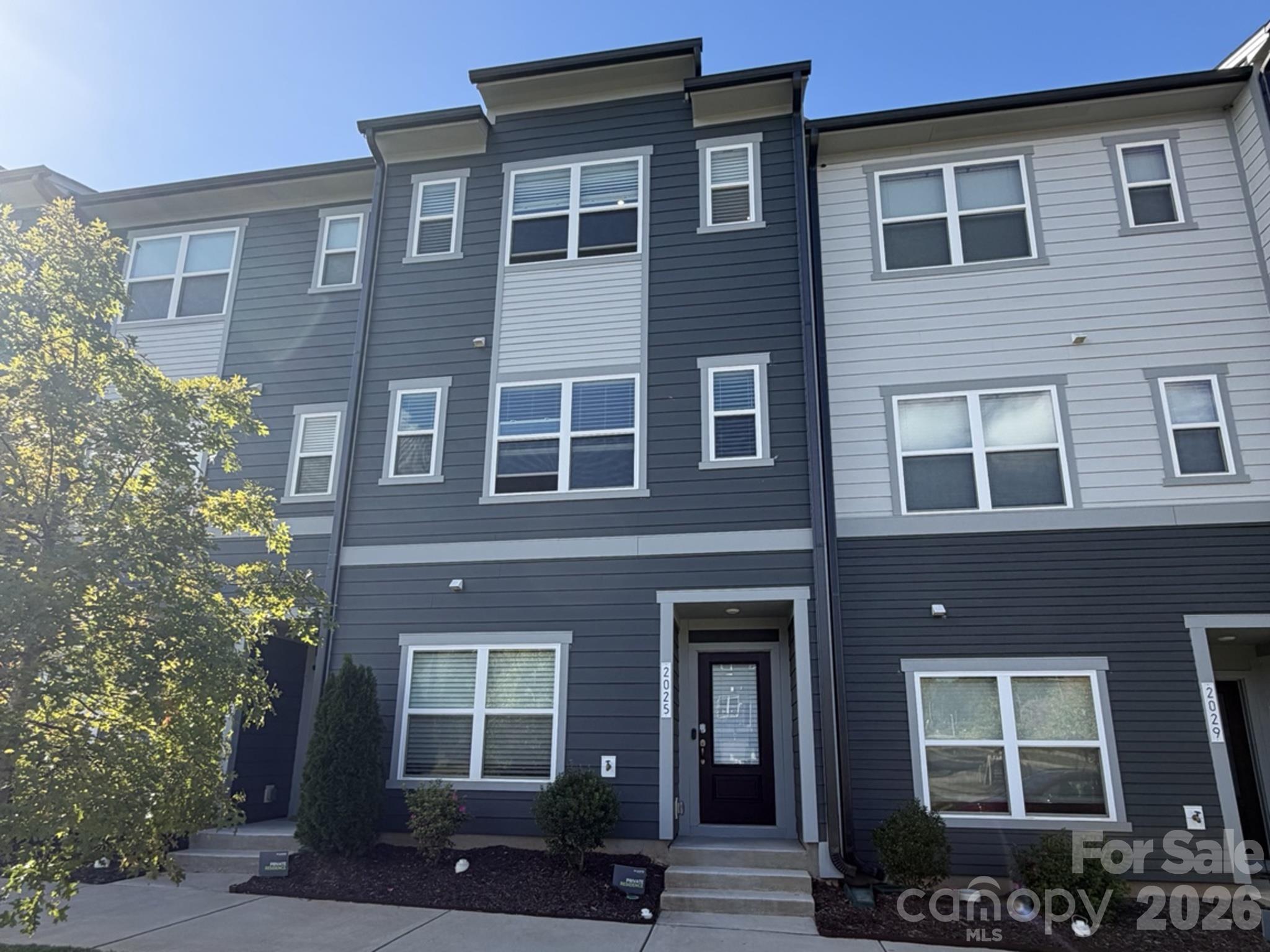Looking for a place that feels tucked away but keeps you close to everything Charlotte has to offer? Welcome to 2025 Evolve Way in Context at Oakhurst! This three-bedroom, three-and-a-half-bath townhome offers a versatile layout, modern finishes, and a tree-lined backdrop that adds a little extra privacy to everyday living.The main level features a bedroom and full bath, giving you flexibility for guests, a home office, or whatever suits your lifestyle. Upstairs, the open kitchen and living area create a natural gathering space, complete with a large island, walk-in pantry, and Frigidaire Gallery appliances. The top floor offers a comfortable retreat in the primary suite, along with an additional bedroom and full bath.Step out onto the balcony for a little fresh air, enjoy your morning coffee on the front porch, or appreciate the convenience of an attached garage with EV charging compatibility. With lawn maintenance included, you can spend less time on upkeep and more time enjoying your home. Shopping, dining, local favorites, and major highway access are all nearby, making it easy to get around Charlotte while still having a space to come home and unwind.With 1,717 square feet of living space, a thoughtful three-level layout, and a setting that offers both convenience and a touch of privacy, this home is worth a closer look. The sellers are offering a $6,000 credit at closing, and buyers can also ask about a lender offering a 1% credit at closing, subject to lender terms and eligibility.Professional Pictures and Measurements to follow!